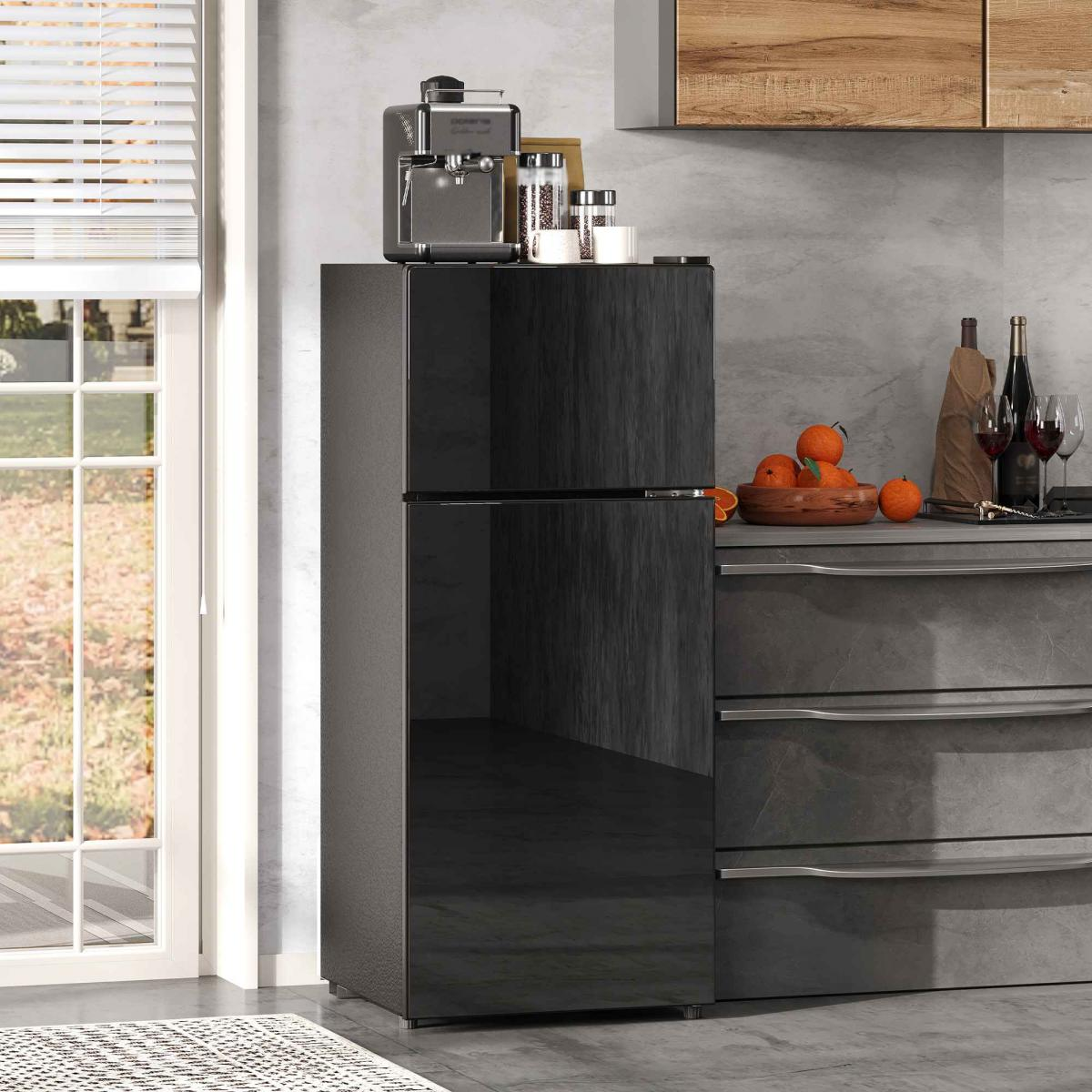 Schwarzer Kühlschrank mit Kaffeemaschine und Obst auf der Arbeitsplatte.