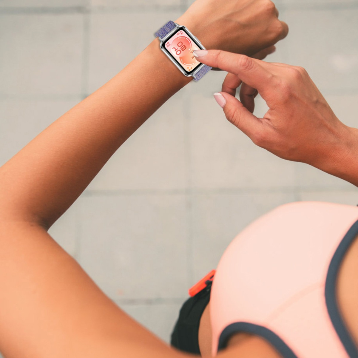 Eine Frau berührt ihr Smartwatch-Display, das die Uhrzeit und Herzfrequenz anzeigt.