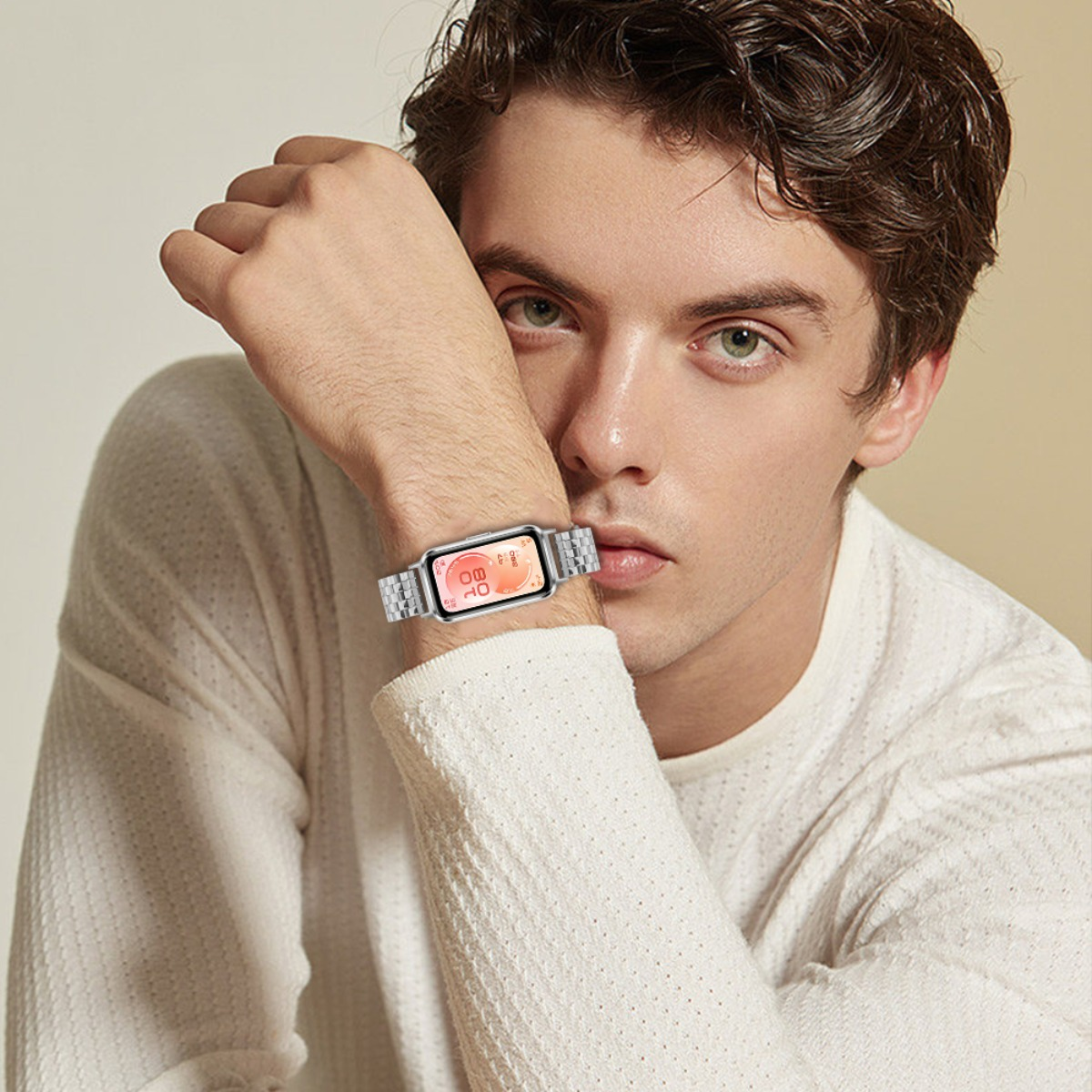 Mann mit silberner Smartwatch am Handgelenk, die eine Uhrzeit anzeigt.