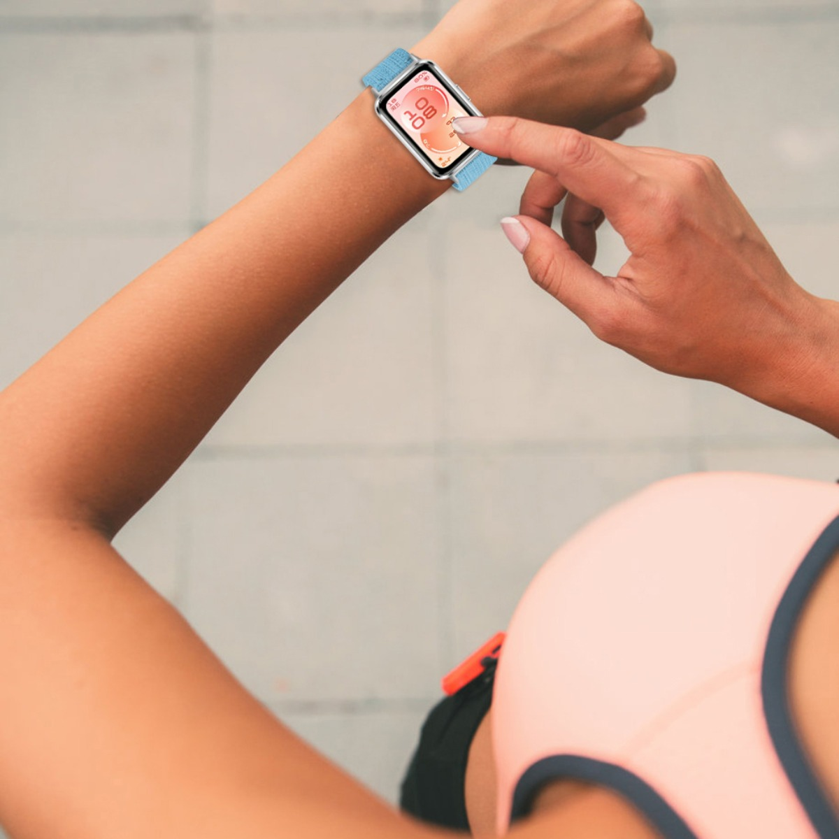 Una persona usa uno smartwatch con cinturino blu, che mostra dati di fitness.