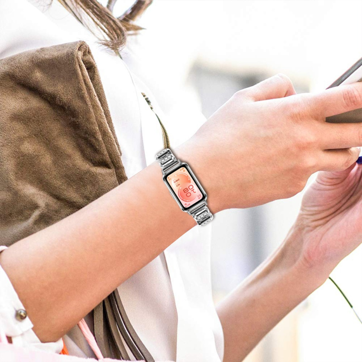 Una donna indossa uno smartwatch con cinturino lucido. Lo schermo mostra l'ora.