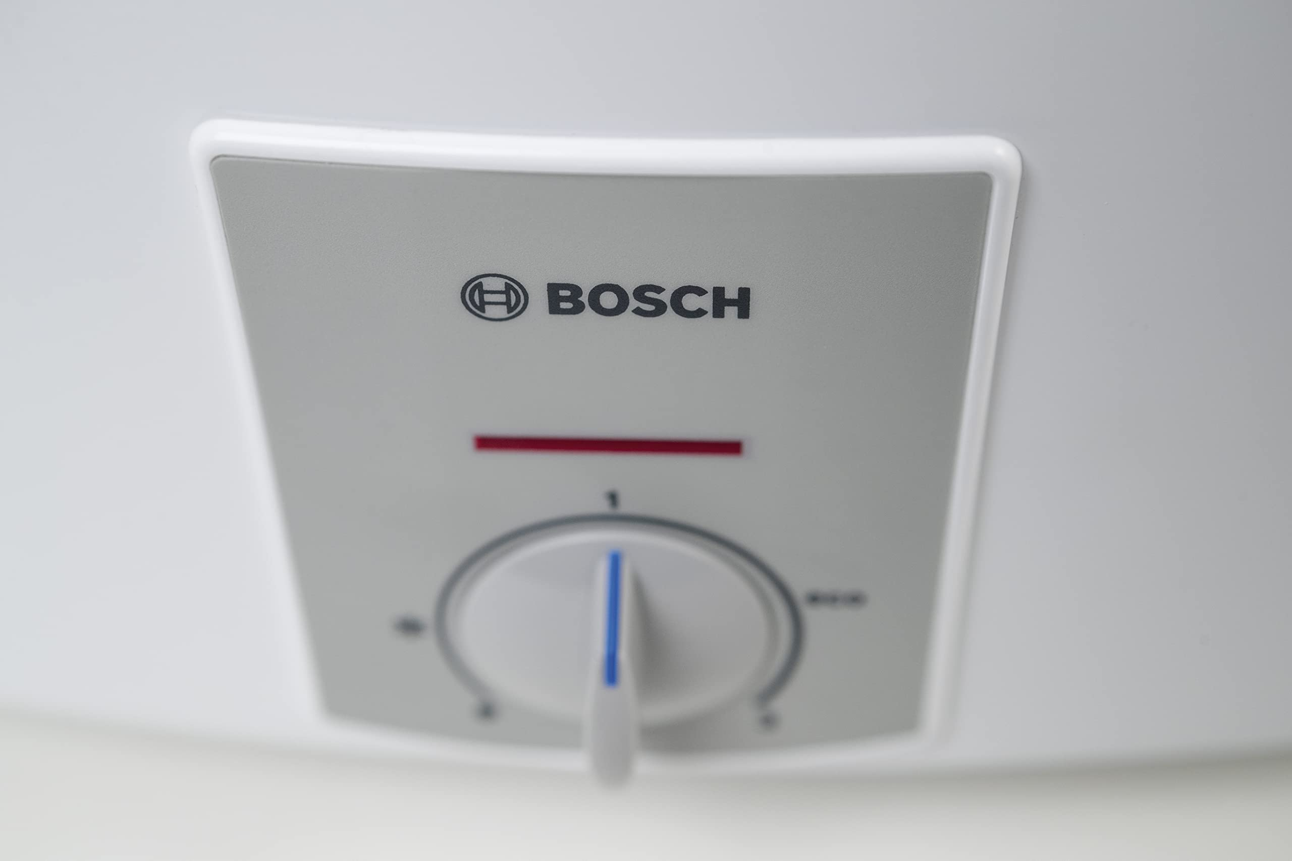 Nahaufnahme des Bosch-Logos und eines Drehknopfes auf weißem Gerät.