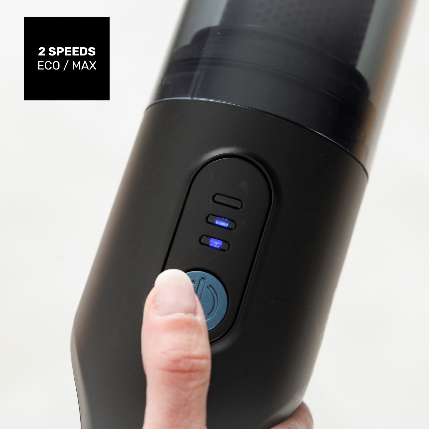 Pulgar presiona el botón de encendido de aspiradora negra con luces indicadoras.