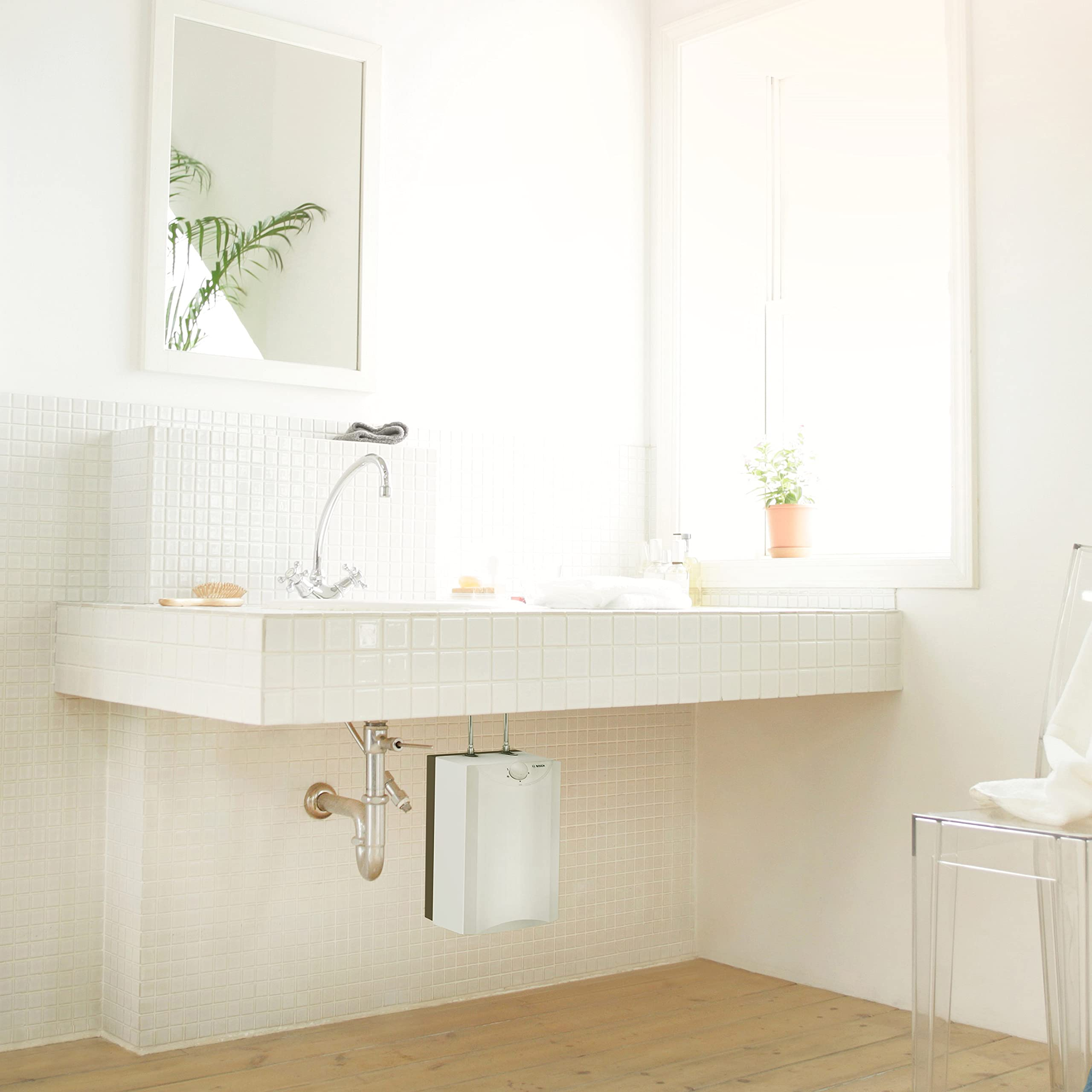 Ein weißes Badezimmer mit Waschbecken, Spiegel, Fenster und Holzboden.