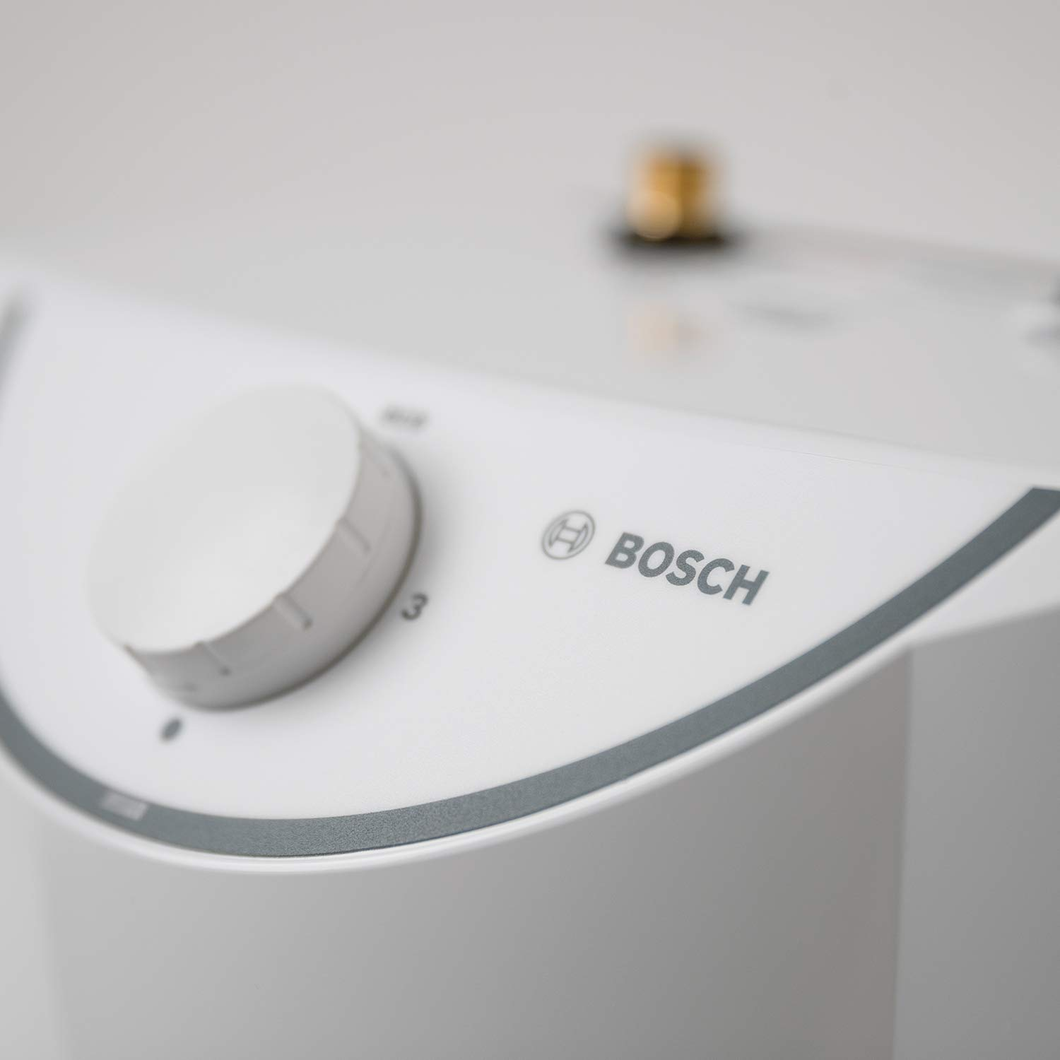 Nahaufnahme eines weißen Bosch-Geräts mit einem Drehknopf und einem Logo.