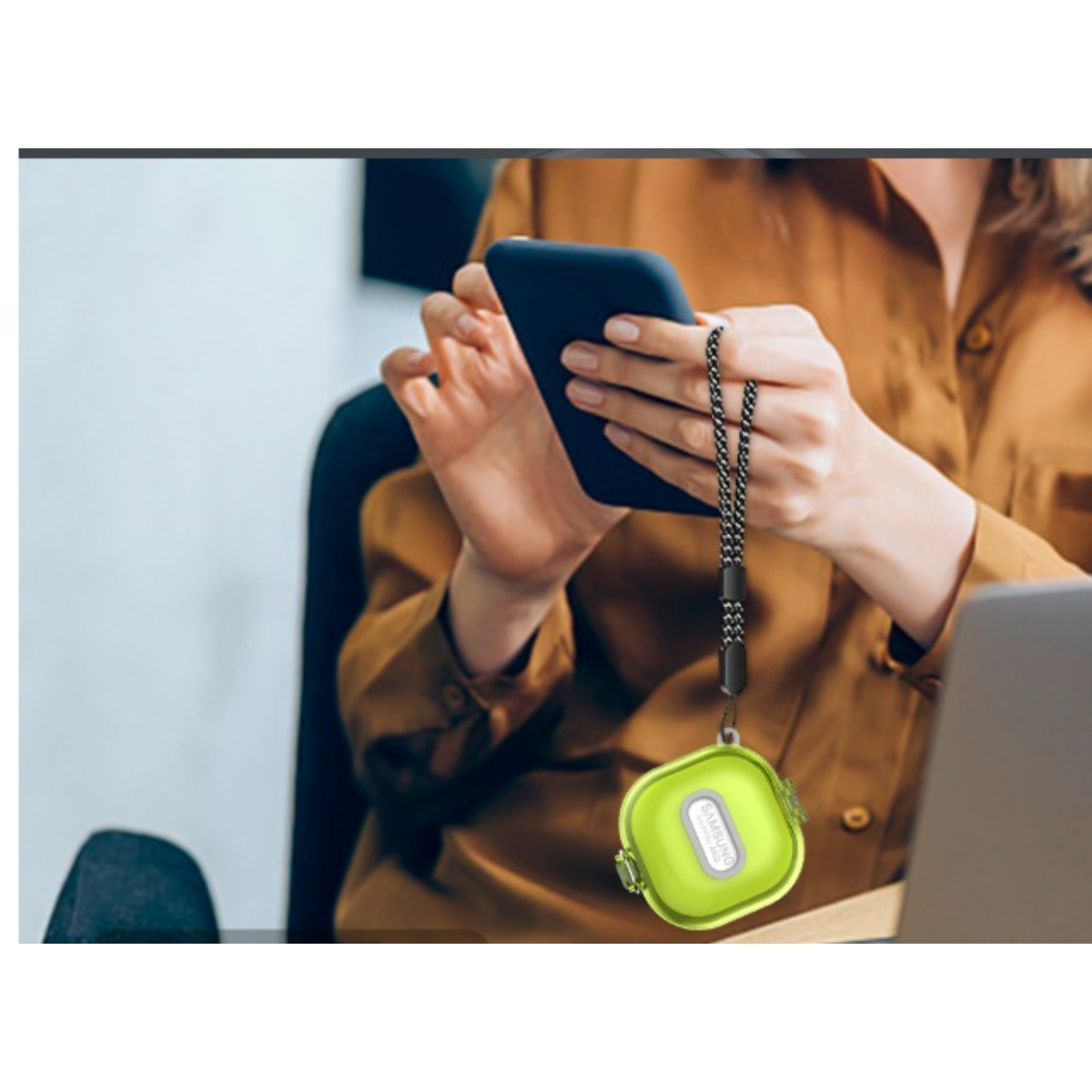 Eine Frau hält ein Smartphone und eine grüne H ülle mit einem Riemen.
