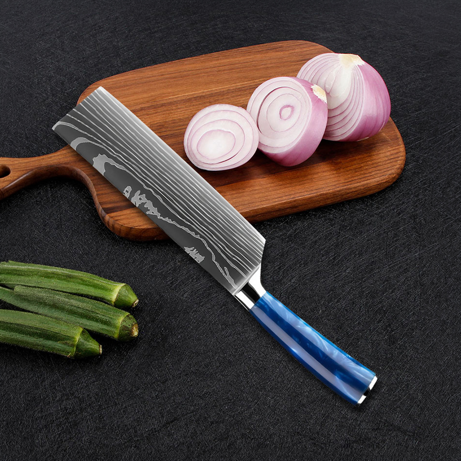 Un cuchillo de Damasco con mango azul yace sobre una tabla de madera con cebollas rojas y okra cortadas.