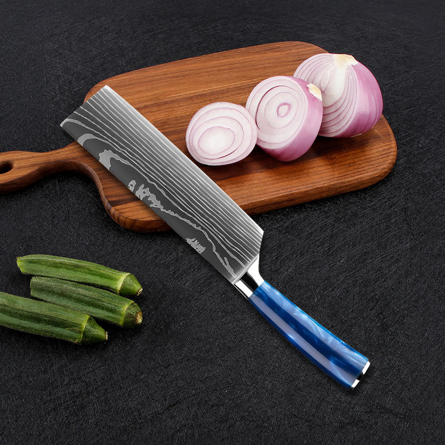 Un cuchillo de chef con mango azul descansa sobre una tabla de madera junto a cebollas y ocra.