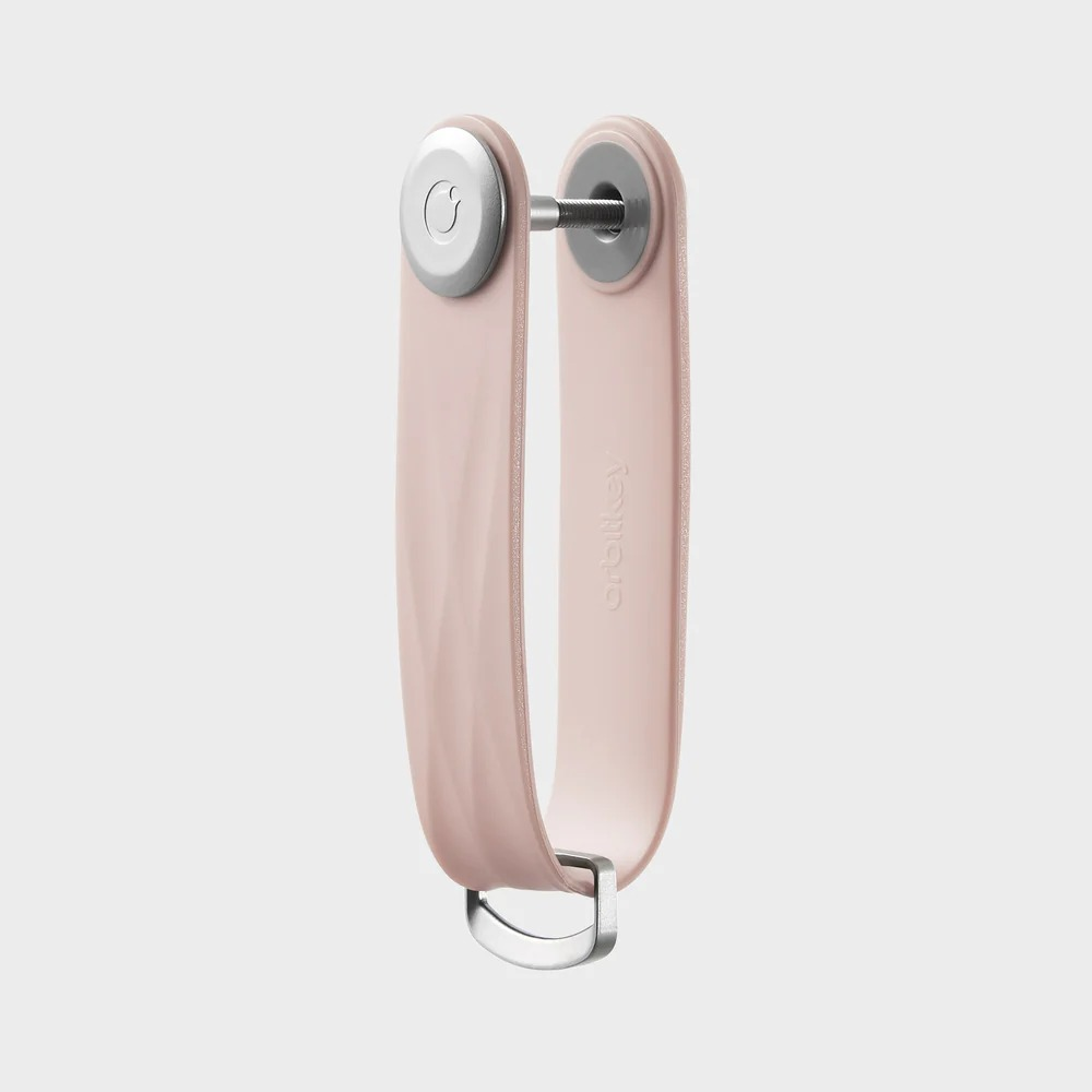 Un organizer per chiavi Orbitkey rosa cipria con ferramenta argentata su sfondo grigio.