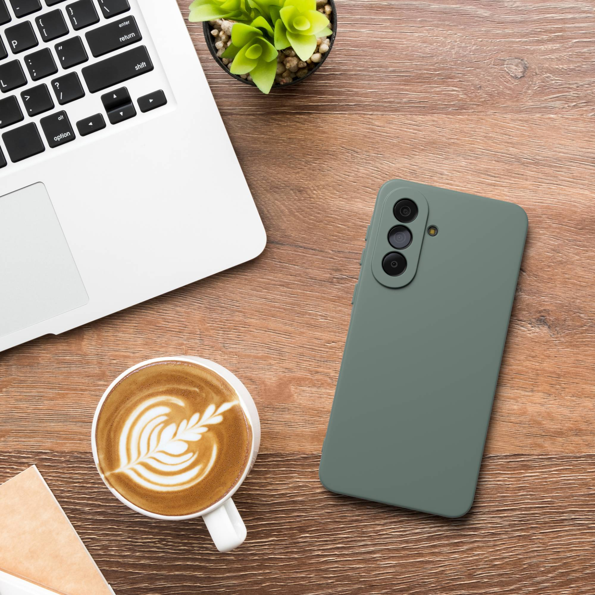 Ein Laptop, eine Tasse Kaffee und ein Handy liegen auf einem Holztisch.