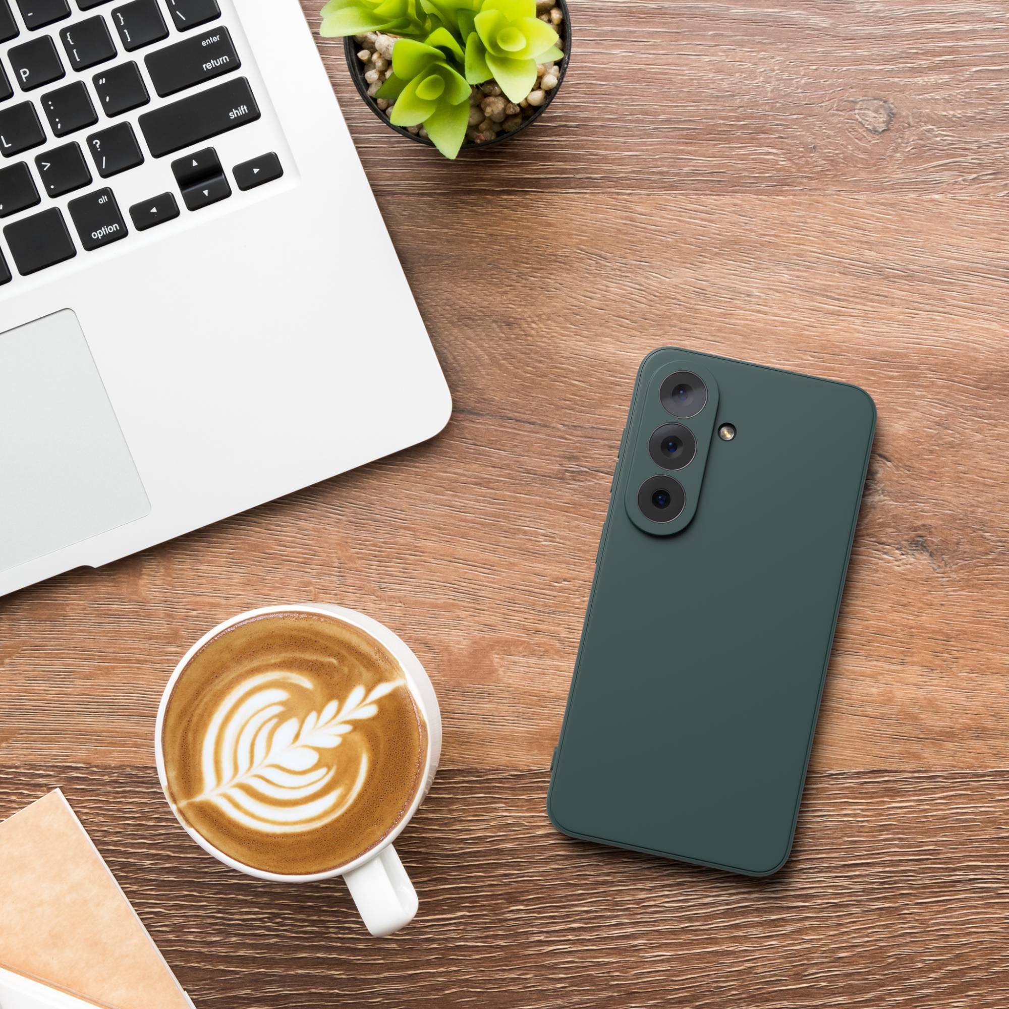 Dunkelgrünes Smartphone, Laptop, Kaffee und Pflanze auf Holztisch.