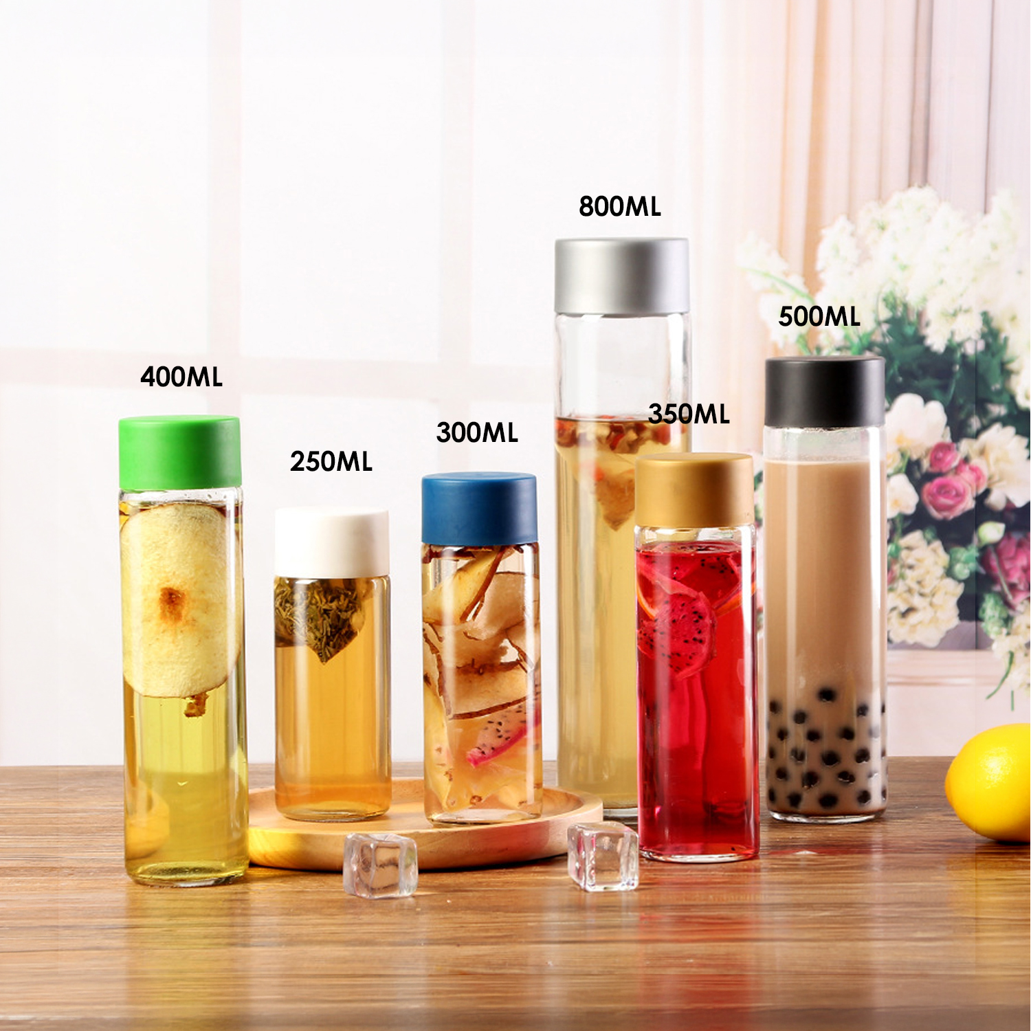 Seis botellas de vidrio con varias bebidas y frutas, sobre una mesa de madera.