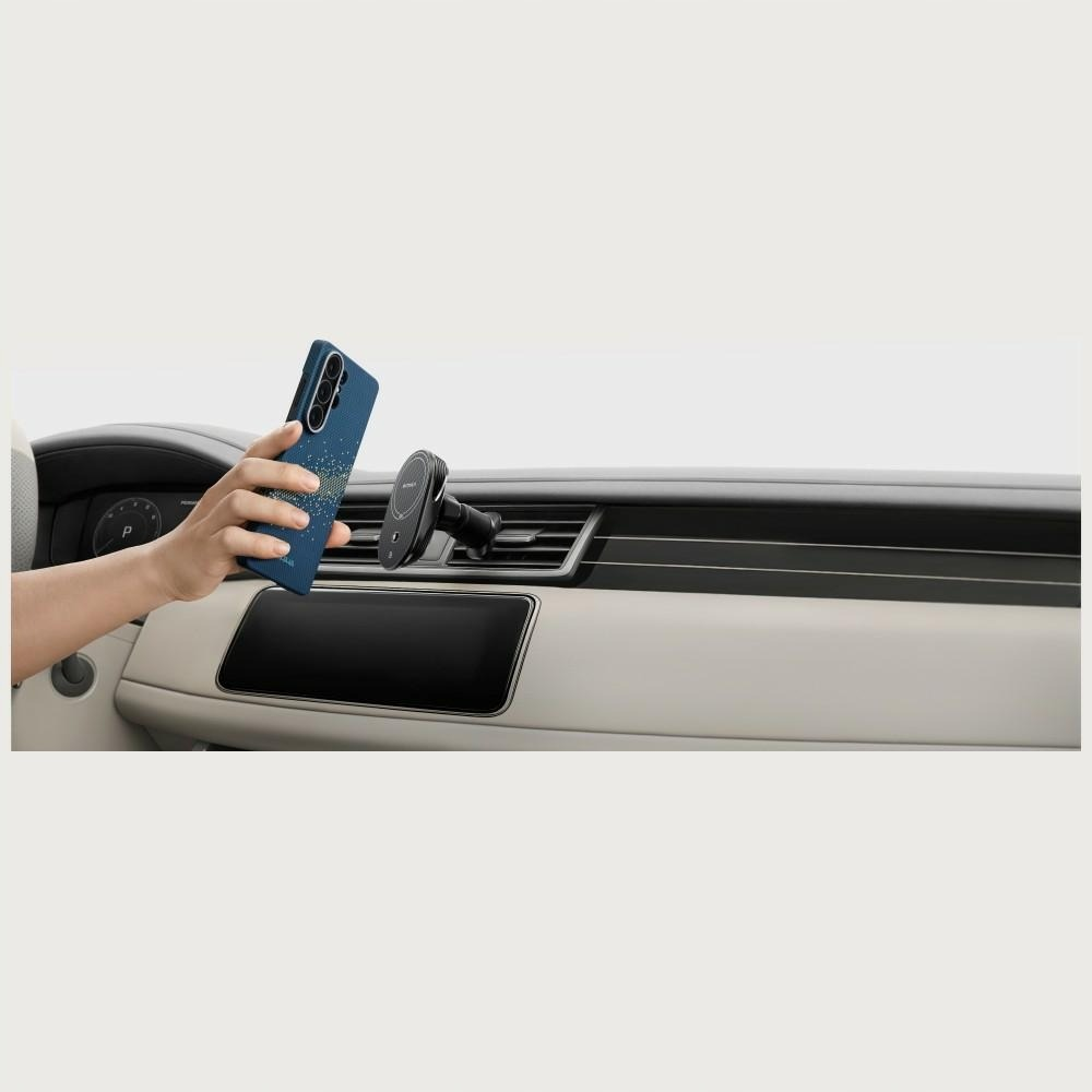 Mano sujetando teléfono azul cerca del salpicadero del coche con soporte.