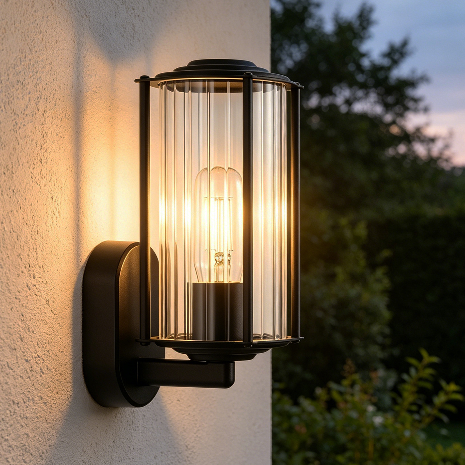 Eine schwarze Wandleuchte mit Glaszylinder und Glühbirne leuchtet.