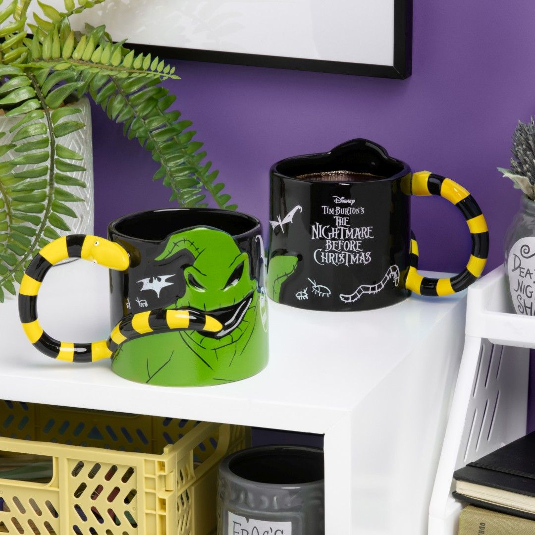 Dwa kubki "Miasteczko Halloween". Jeden zielony z twarzą Oogie Boogie, jeden czarny z tytułem.