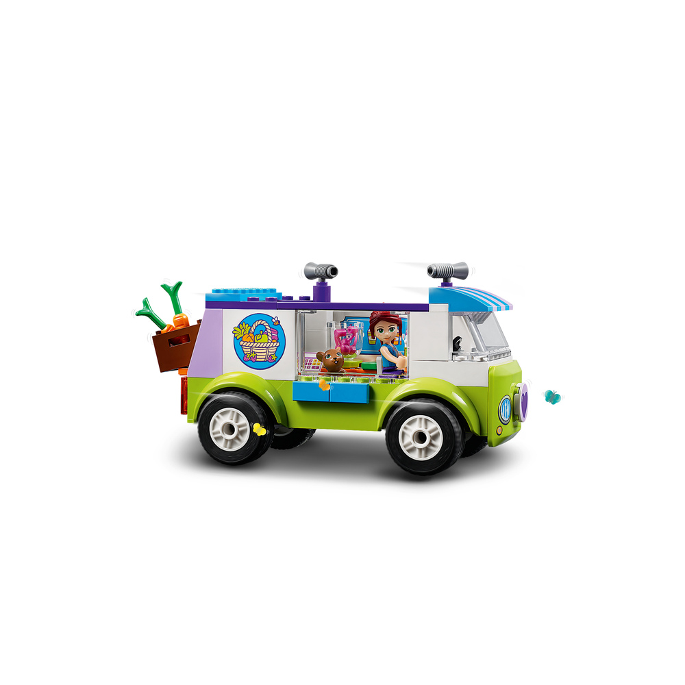 Un furgone Lego verde e bianco con una ragazza e un orso all'interno e carote sul retro.