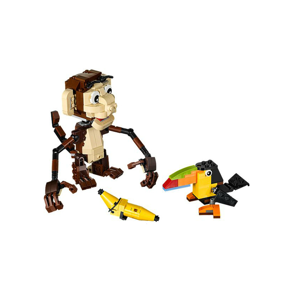 Una scimmia, un tucano e banane Lego su sfondo bianco.