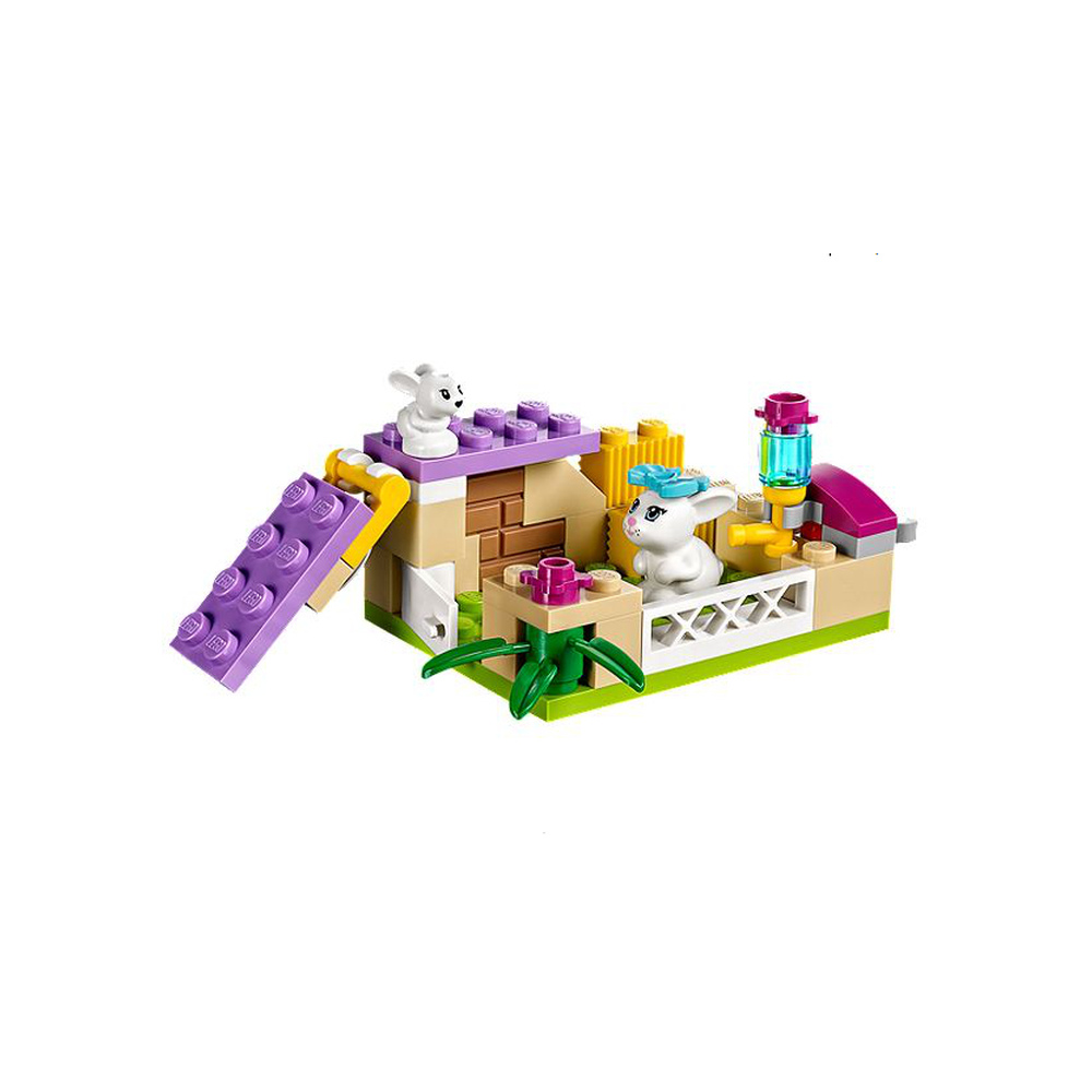Un recinto Lego con due conigli bianchi, piante e una struttura a rampa.
