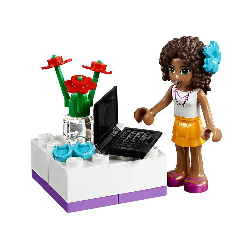 Una ragazza Lego con fiori, laptop e occhiali su un blocco bianco.
