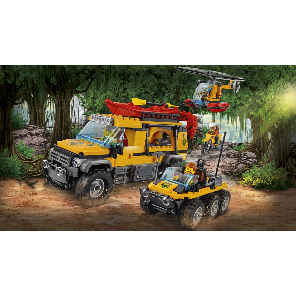 Camion giallo con kayak, veicolo 6x6 e elicottero nella giungla.