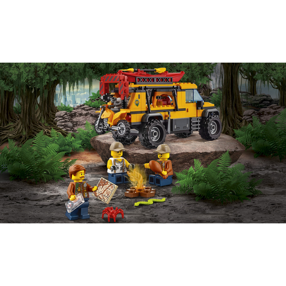 Tre figure Lego sedute attorno a un falò con un veicolo giallo e una moto in un'ambientazione giungla.
