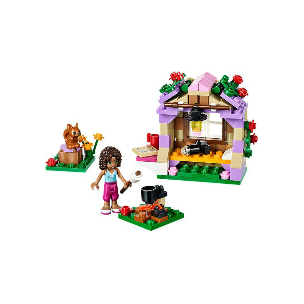 Una bambina Lego vicino a un falò, una casa e uno scoiattolo su un ceppo.