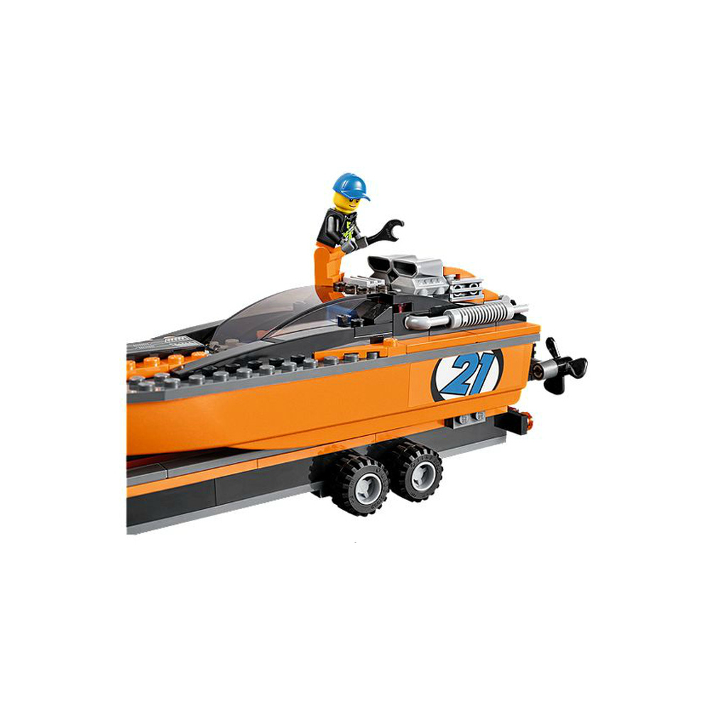 Barca Lego arancione su carrello con pilota in berretto blu e chiave.
