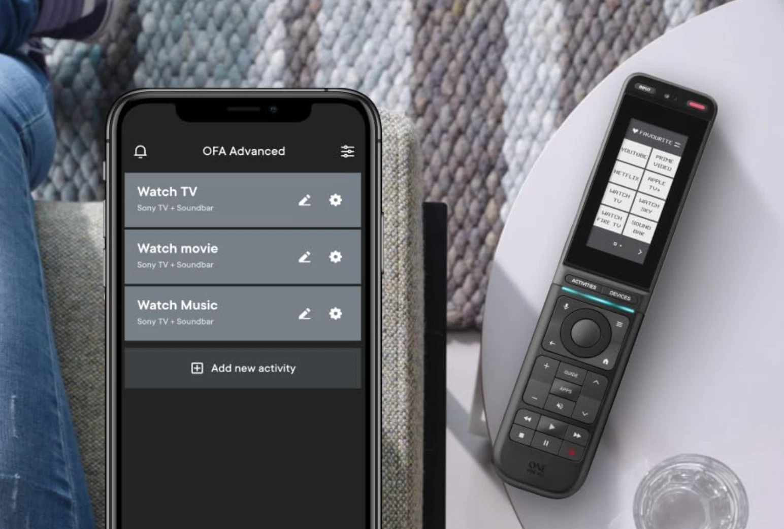 Uno smartphone mostra un'app con attività, accanto un telecomando universale nero.