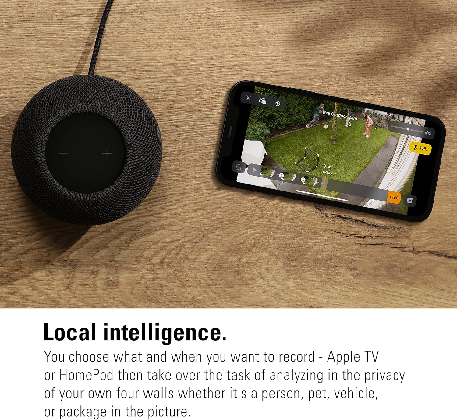 Czarny HomePod i iPhone pokazują widok z kamery bezpieczeństwa w ogrodzie.
