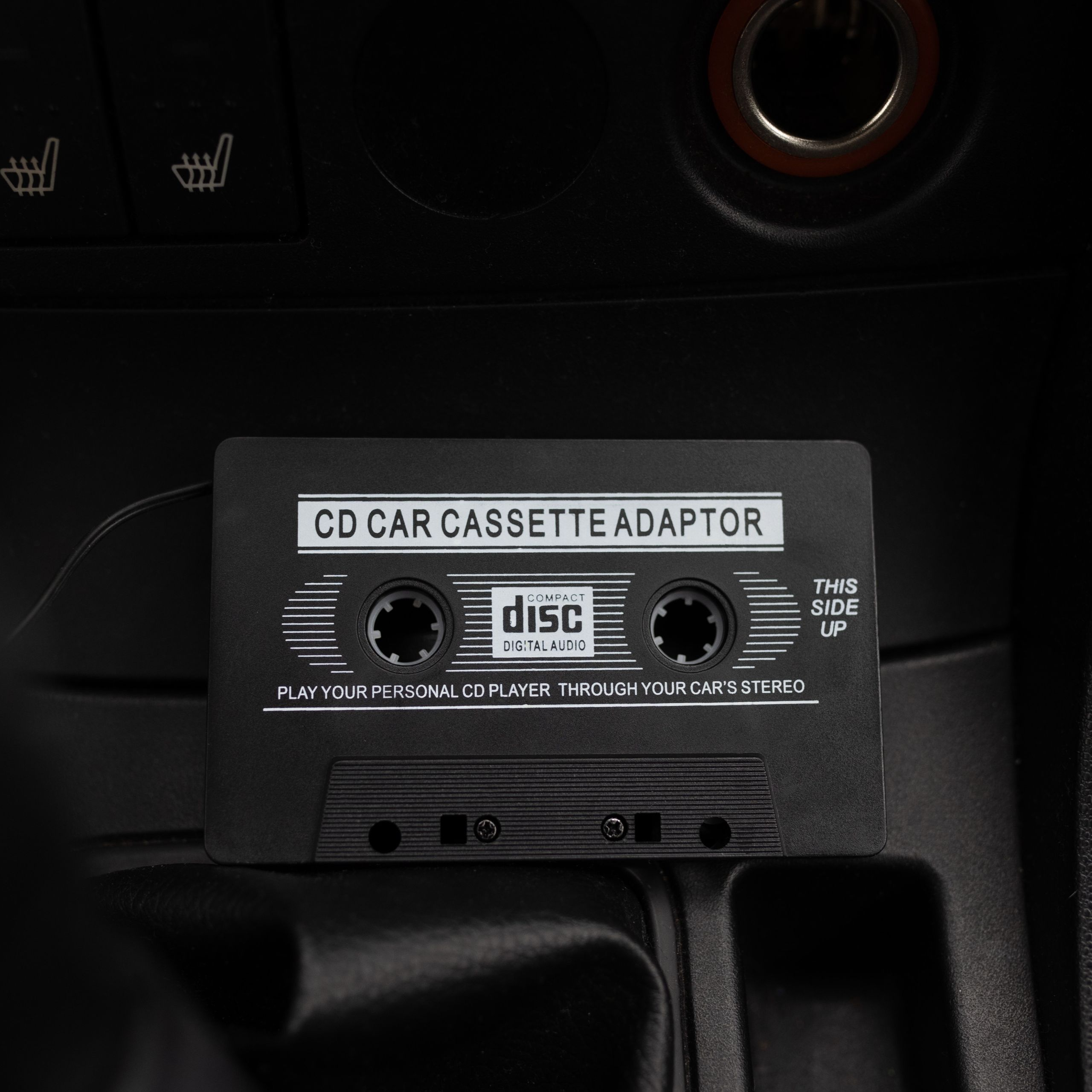 Czarny adapter kasetowy CD do samochodu odtwarza płyty CD przez radio.