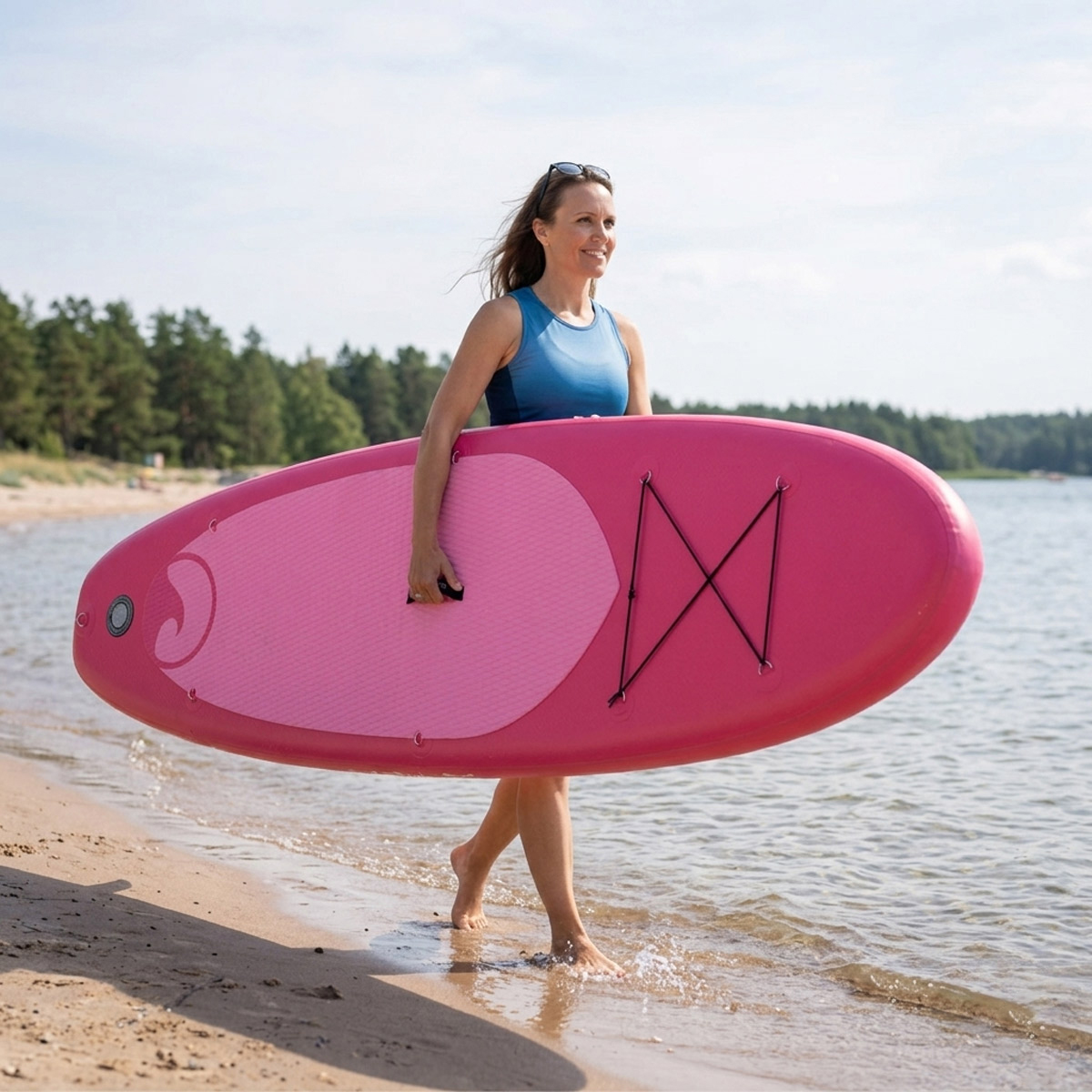 Frau mit pinkem Stand-Up-Paddleboard am Strand