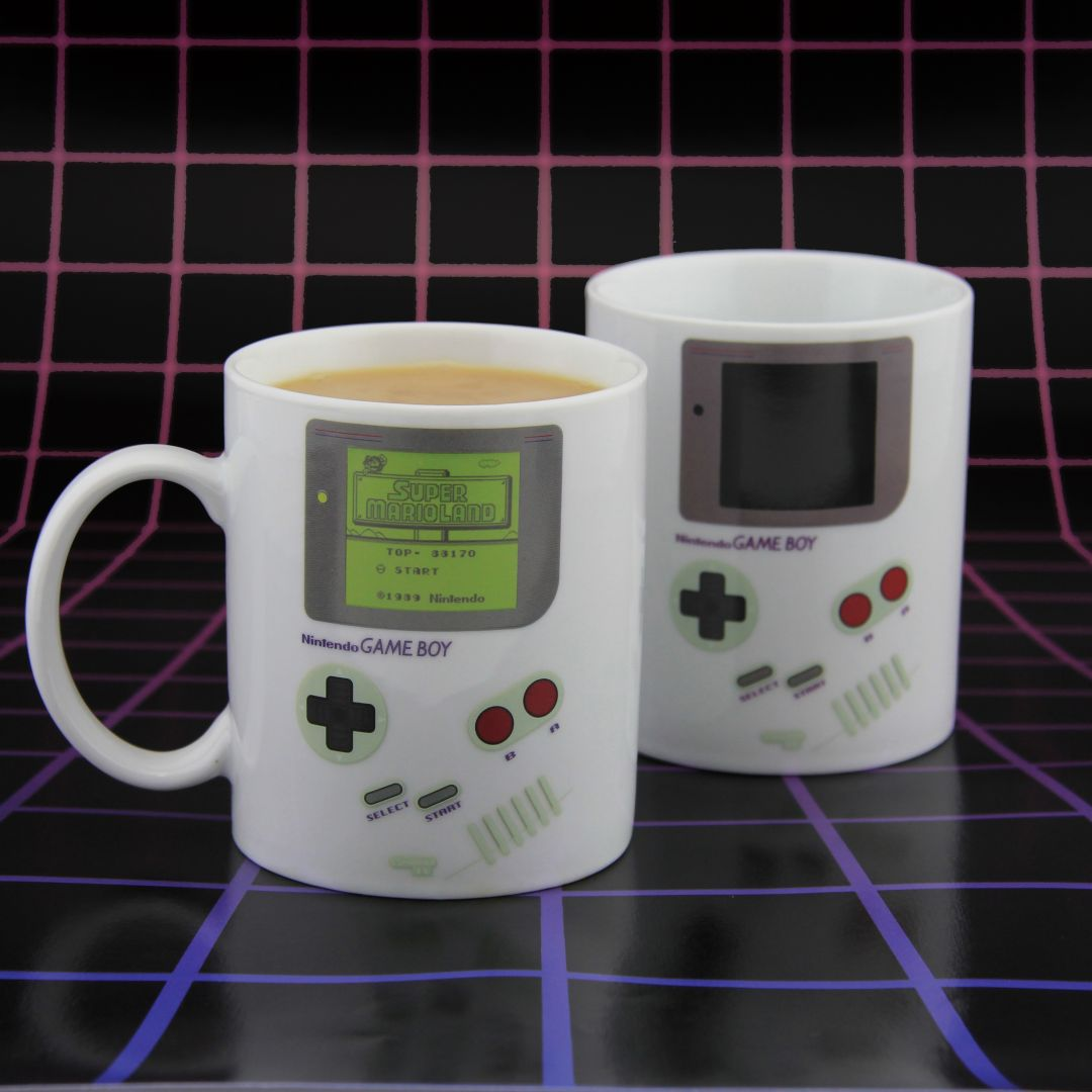 Dos tazas blancas con diseño de Game Boy, una llena de café.