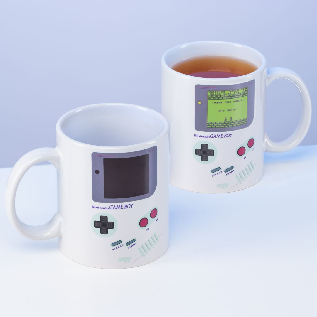 Dos tazas blancas con diseño de Nintendo Game Boy, una llena de té.