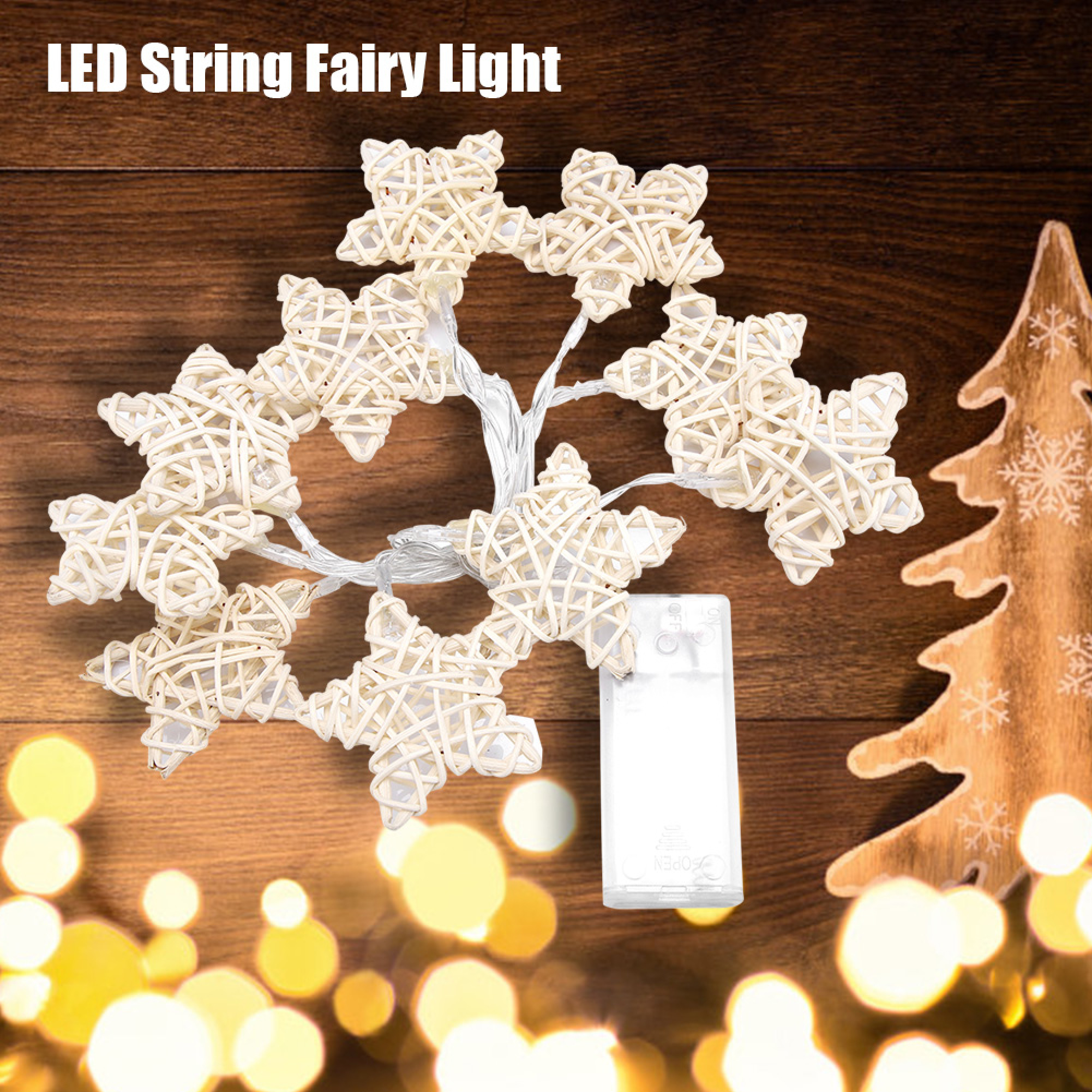 LED-Lichterkette mit Sternen aus Weidengeflecht auf Holz.