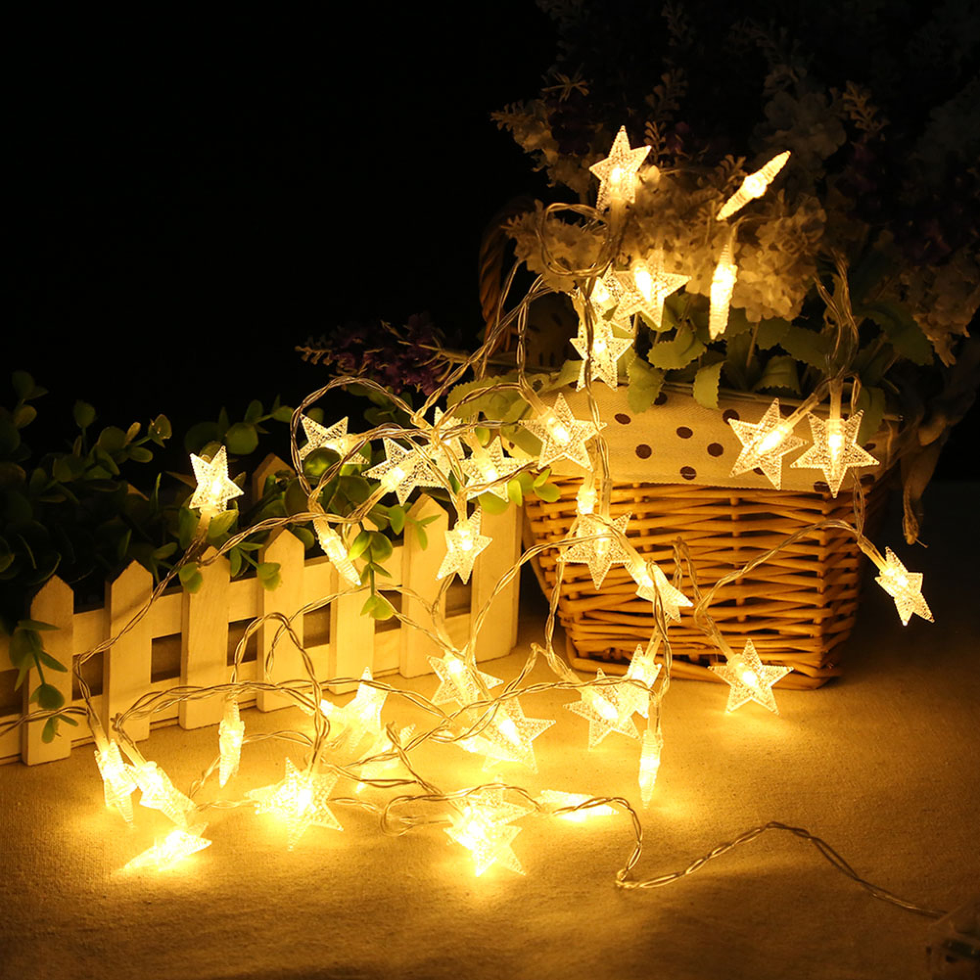 Eine Lichterkette in Sternform leuchtet warm vor einem dunklen Hintergrund.