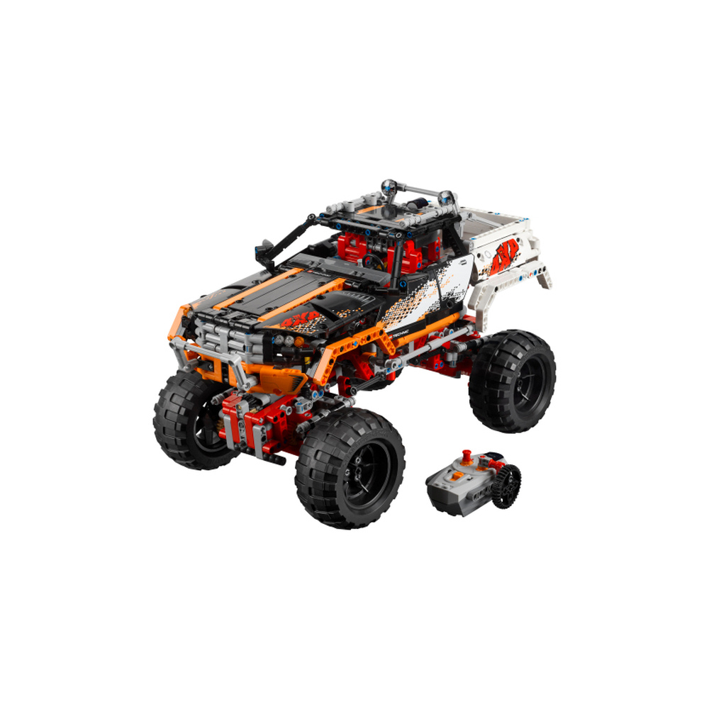 Un dettagliato camion fuoristrada Lego arancione e nero con ruote grandi e un piccolo veicolo telecomandato accanto.