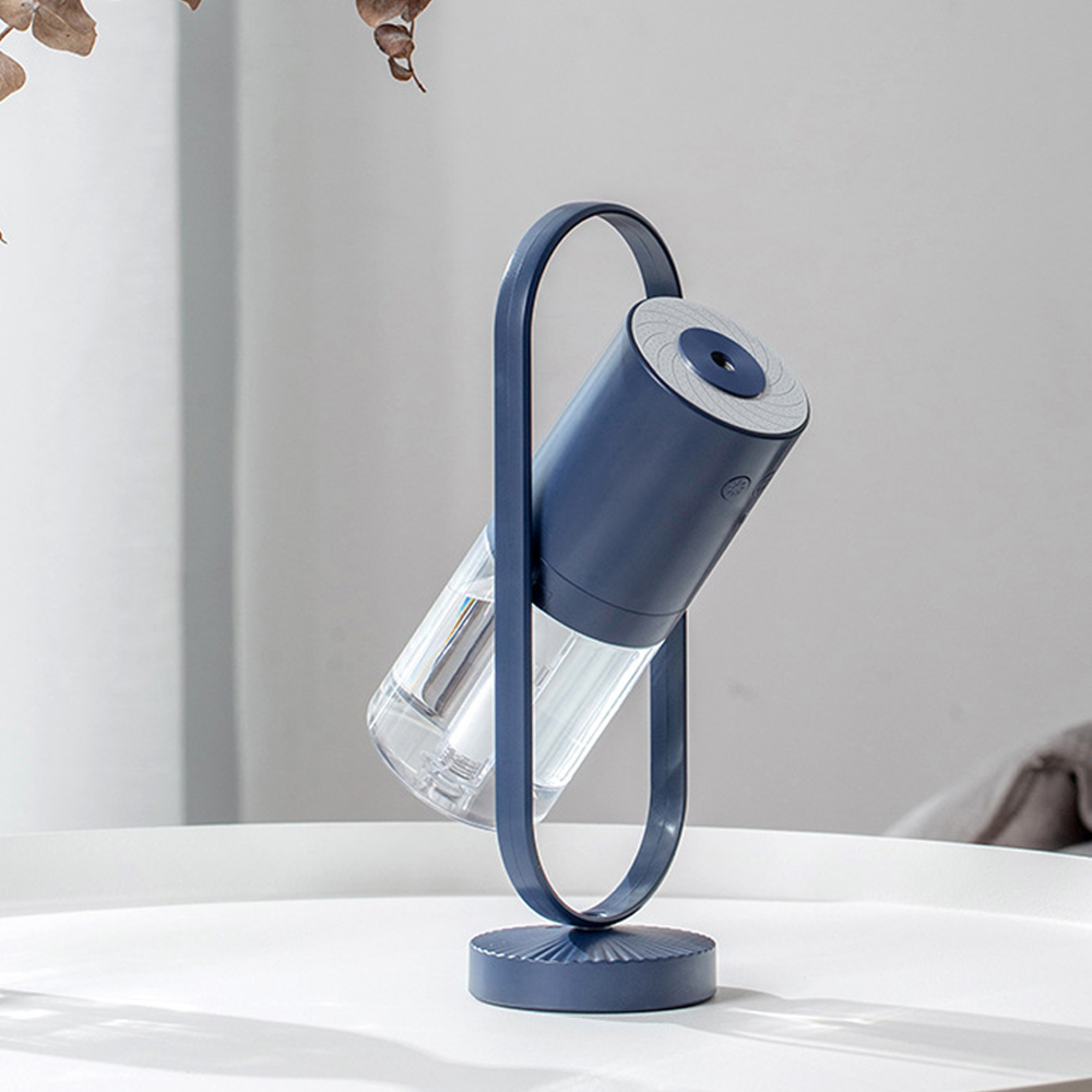 Ein blauer Luftbefeuchter mit transparentem Behälter steht auf einem weißen Tisch.