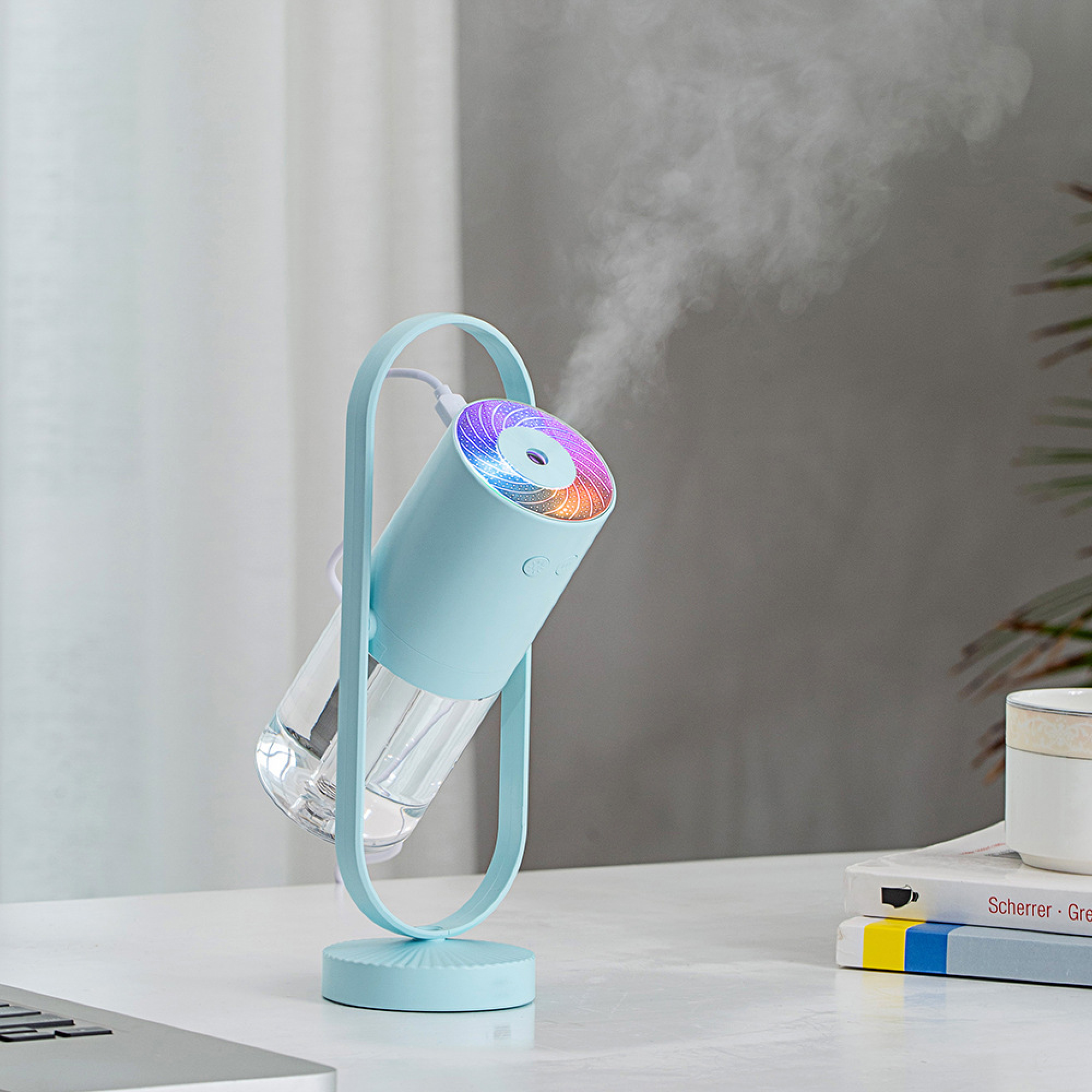 Ein blauer Luftbefeuchter mit einem Rainbow-LED-Licht gibt Dampf ab.