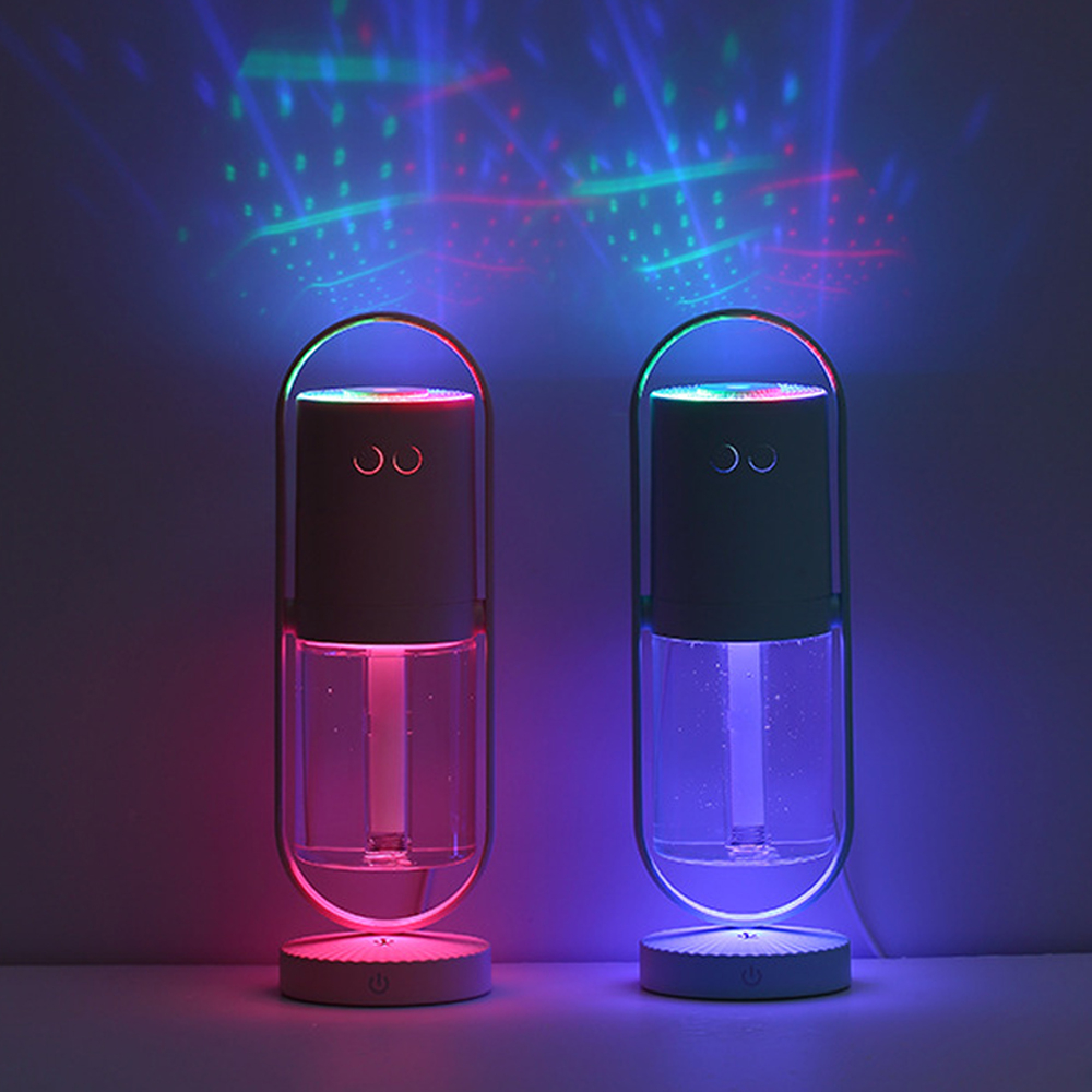 Zwei Luftbefeuchter mit Farbwechsel-LEDs und Projektionen auf einer dunklen Wand.
