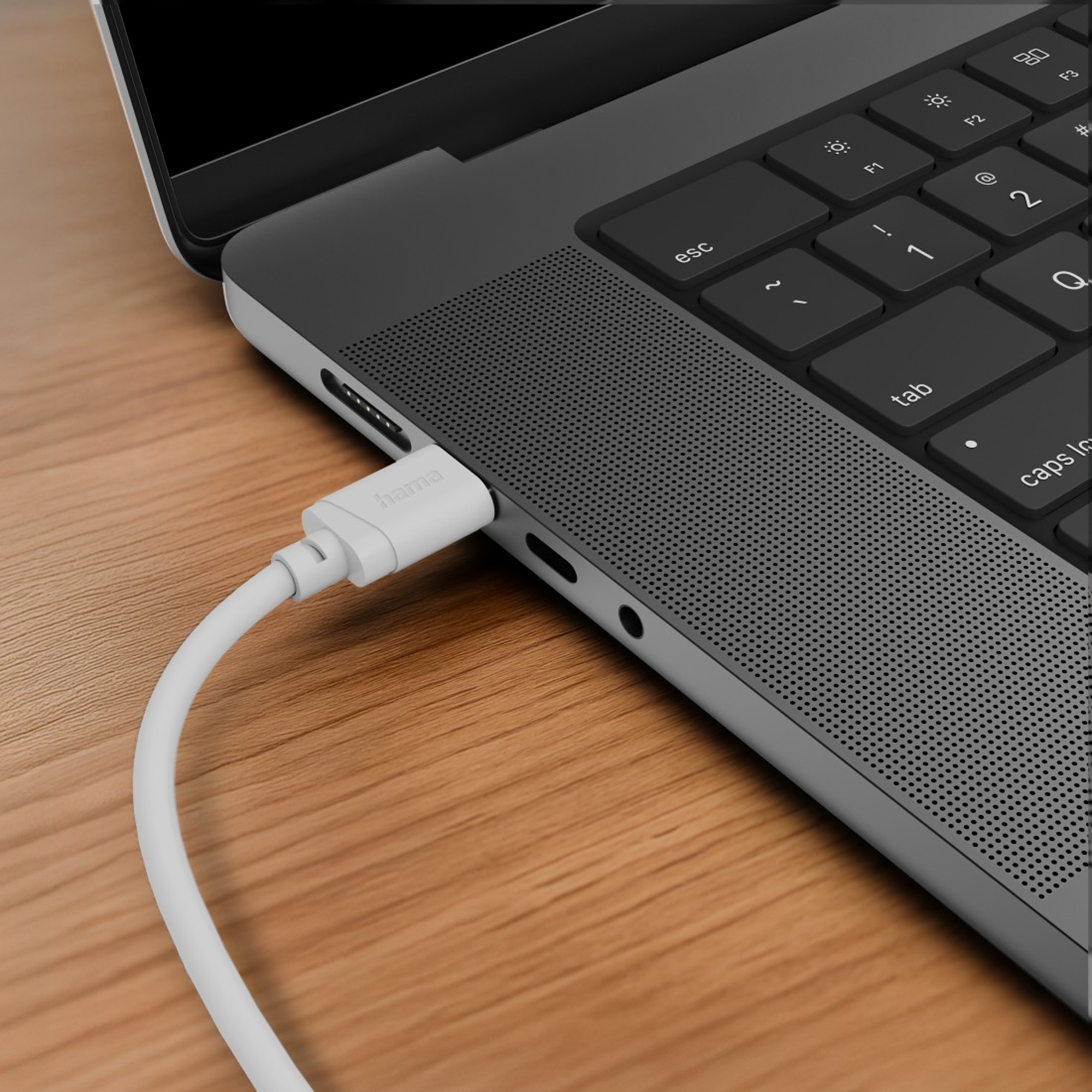 Ein weißes Kabel ist in einen Laptop eingesteckt. Nahaufnahme.