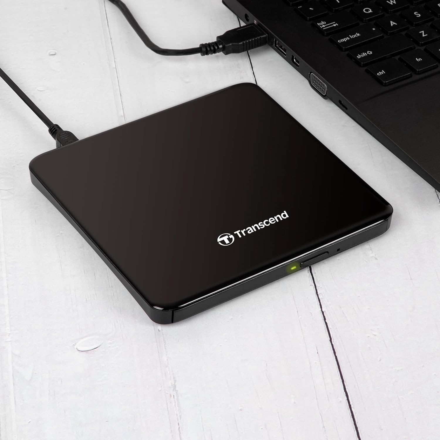 Schwarzes externes Laufwerk ist über USB mit einem Laptop verbunden.