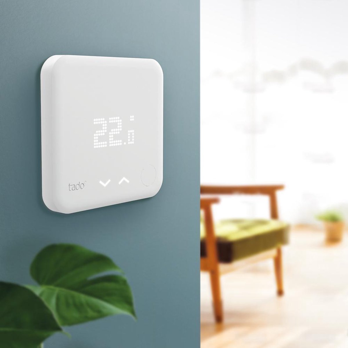 A white thermostat with a digital display shows 22 degrees.