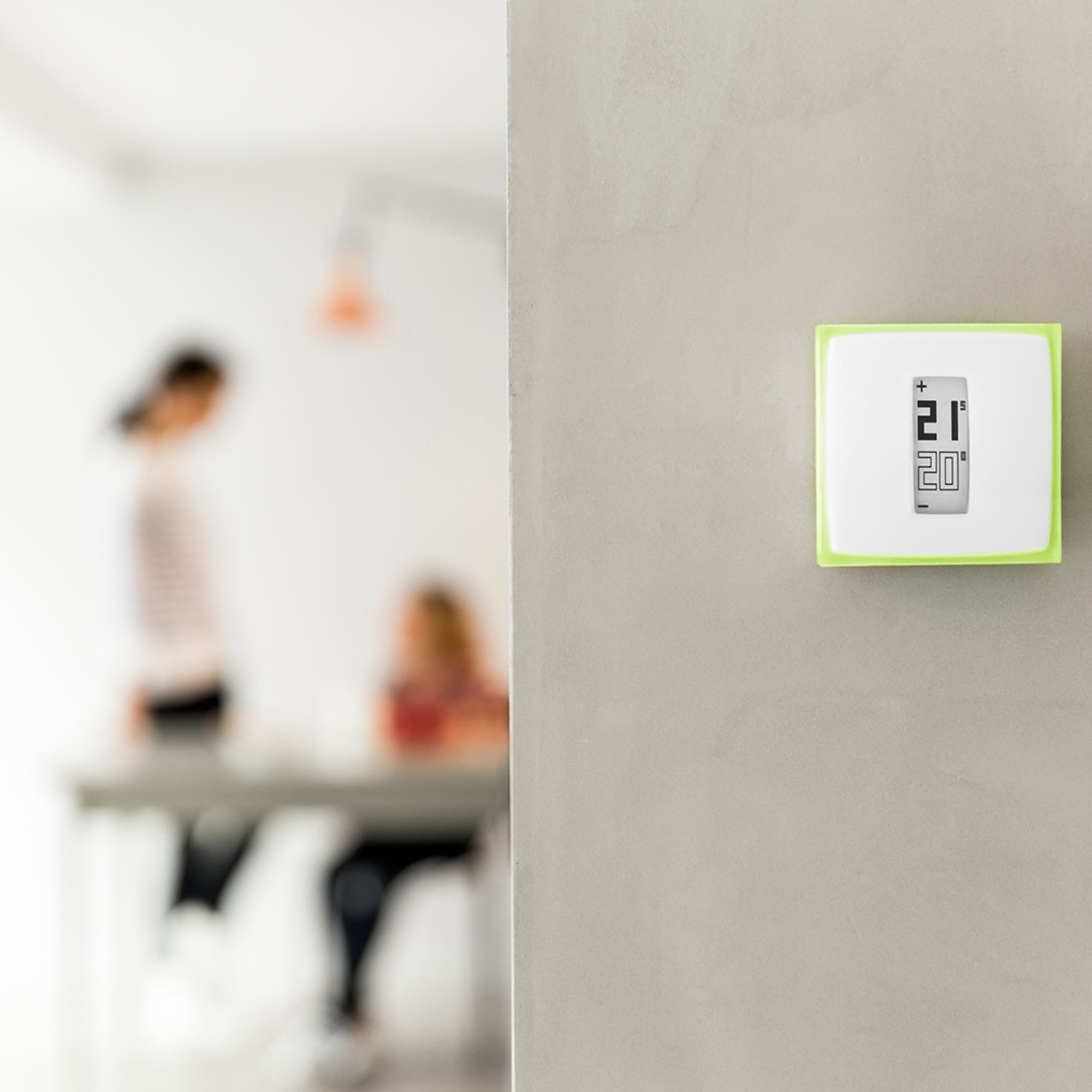 A thermostat displaying 21C above 20C on a gray wall.