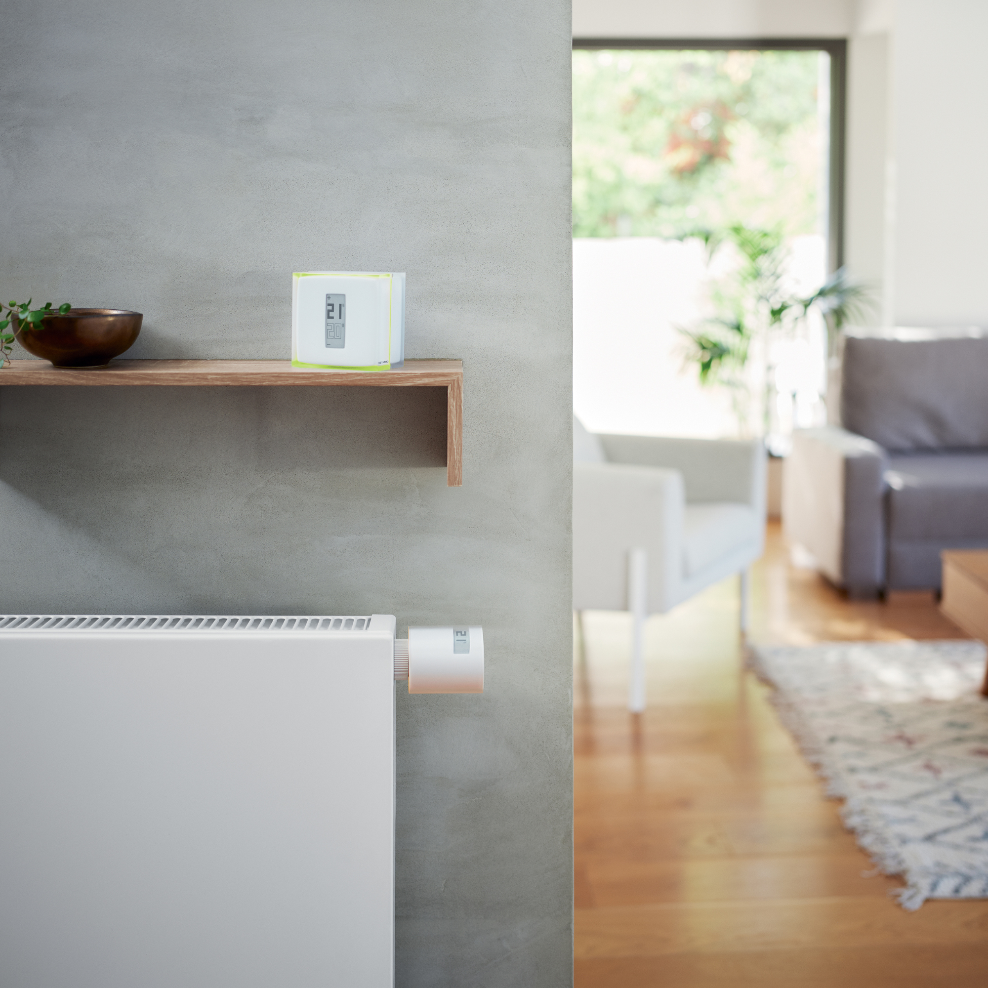 A thermostat shows 21 degrees, a radiator beside it. A shelf with a bowl.