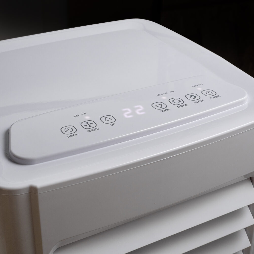Close-up van een witte airconditioner met digitale bedieningselementen die 22 weergeven.