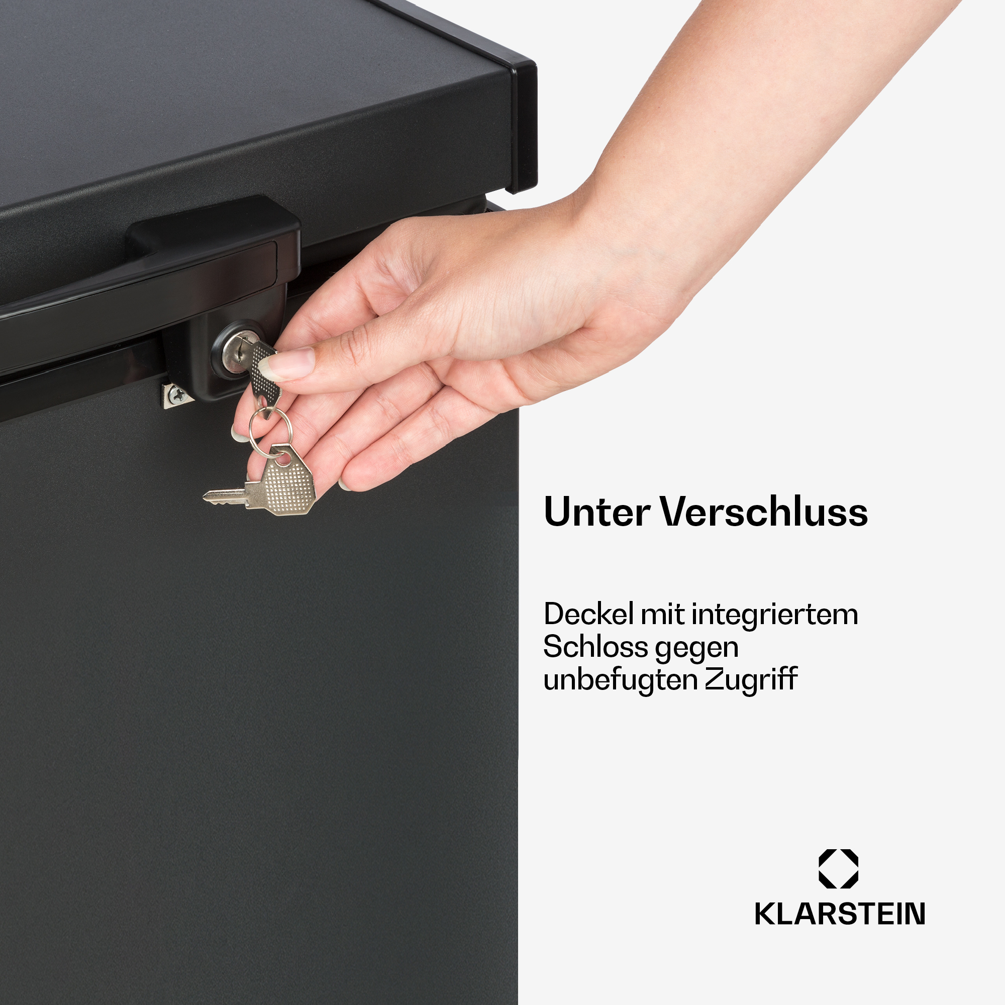 Eine Hand dreht einen Schlüssel in ein schwarzes Schloss an einer Truhe.