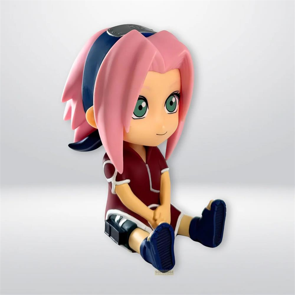 Una figura chibi de Sakura Haruno con pelo rosa y ojos verdes está sentada.