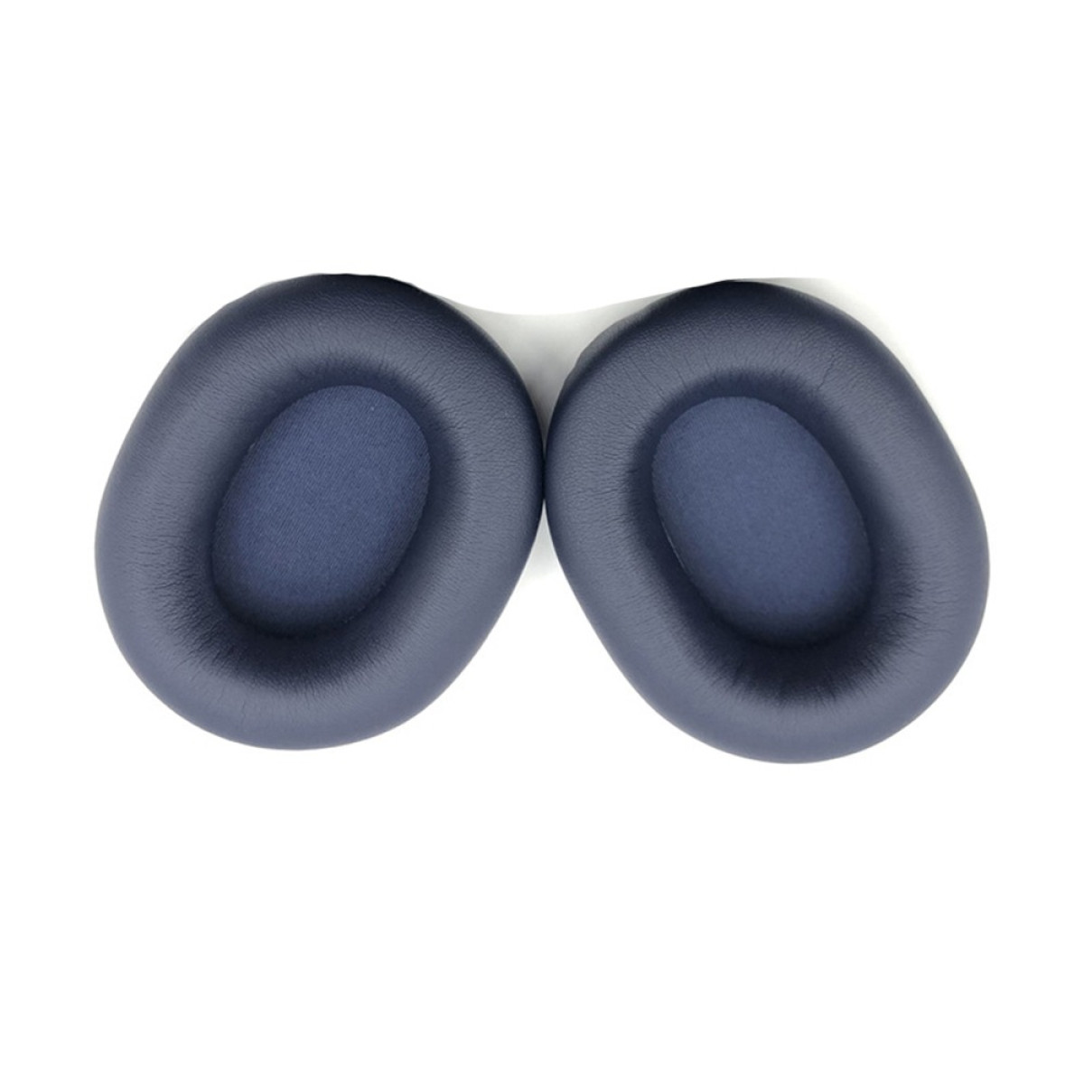 Due cuscinetti auricolari blu scuro giacciono uno accanto all'altro su sfondo bianco.