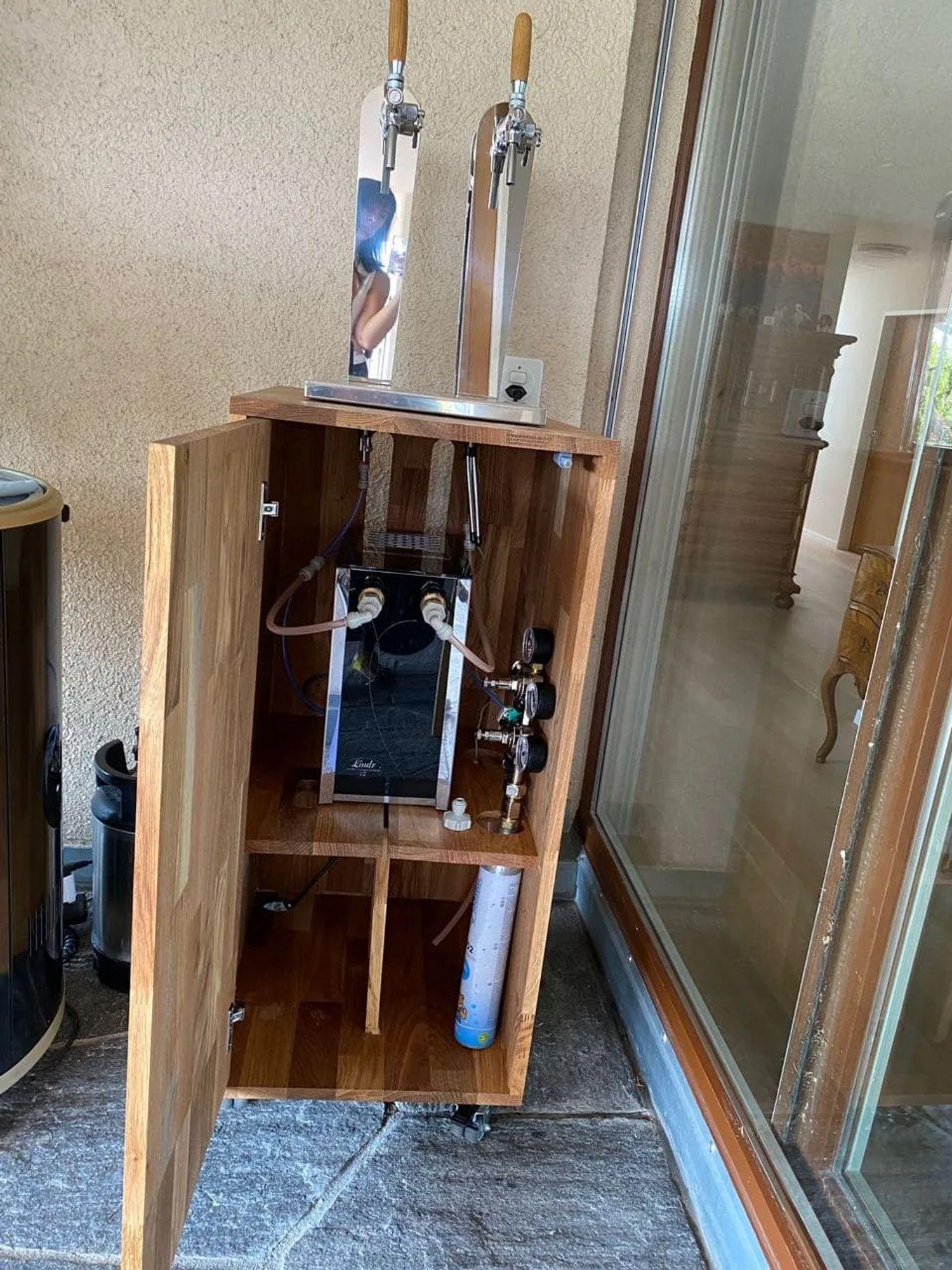 Mobile in legno con spillatori di birra, tubi e manometri.