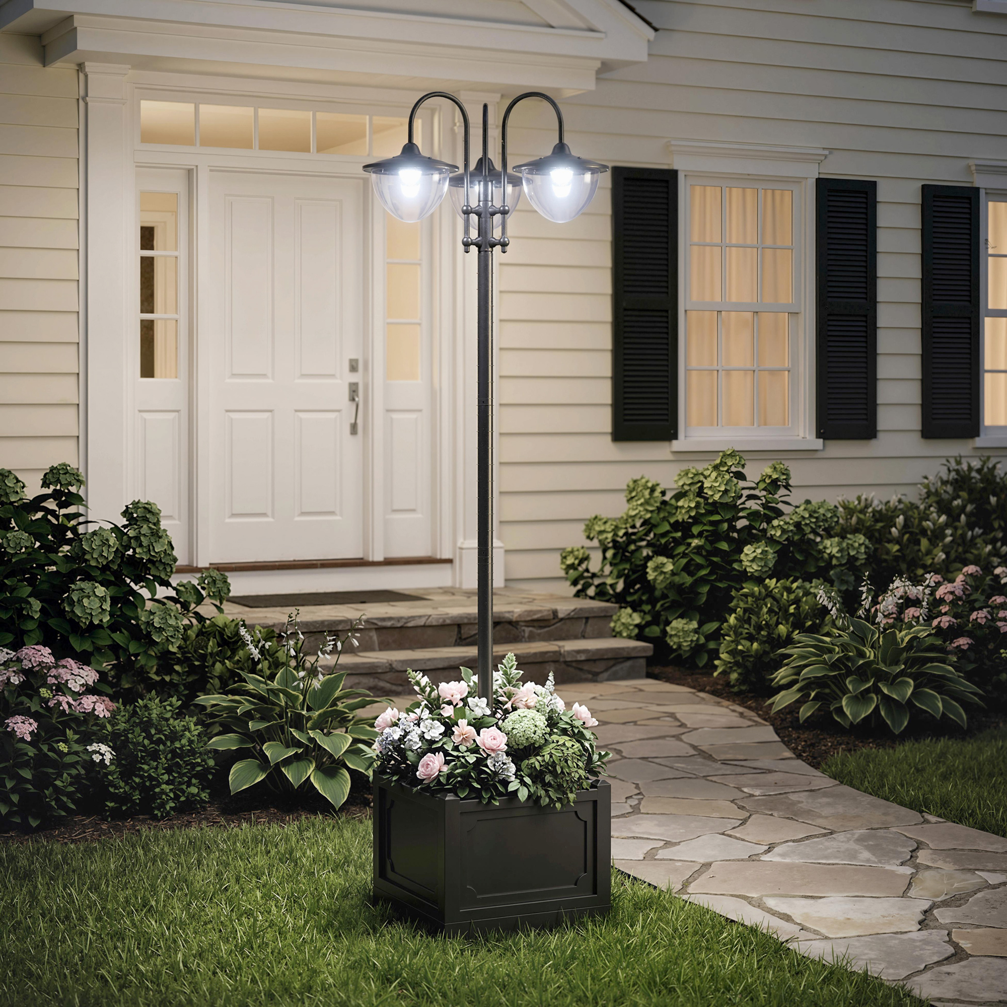 Un poste de luz exterior de tres luces con jardinera frente a una casa.